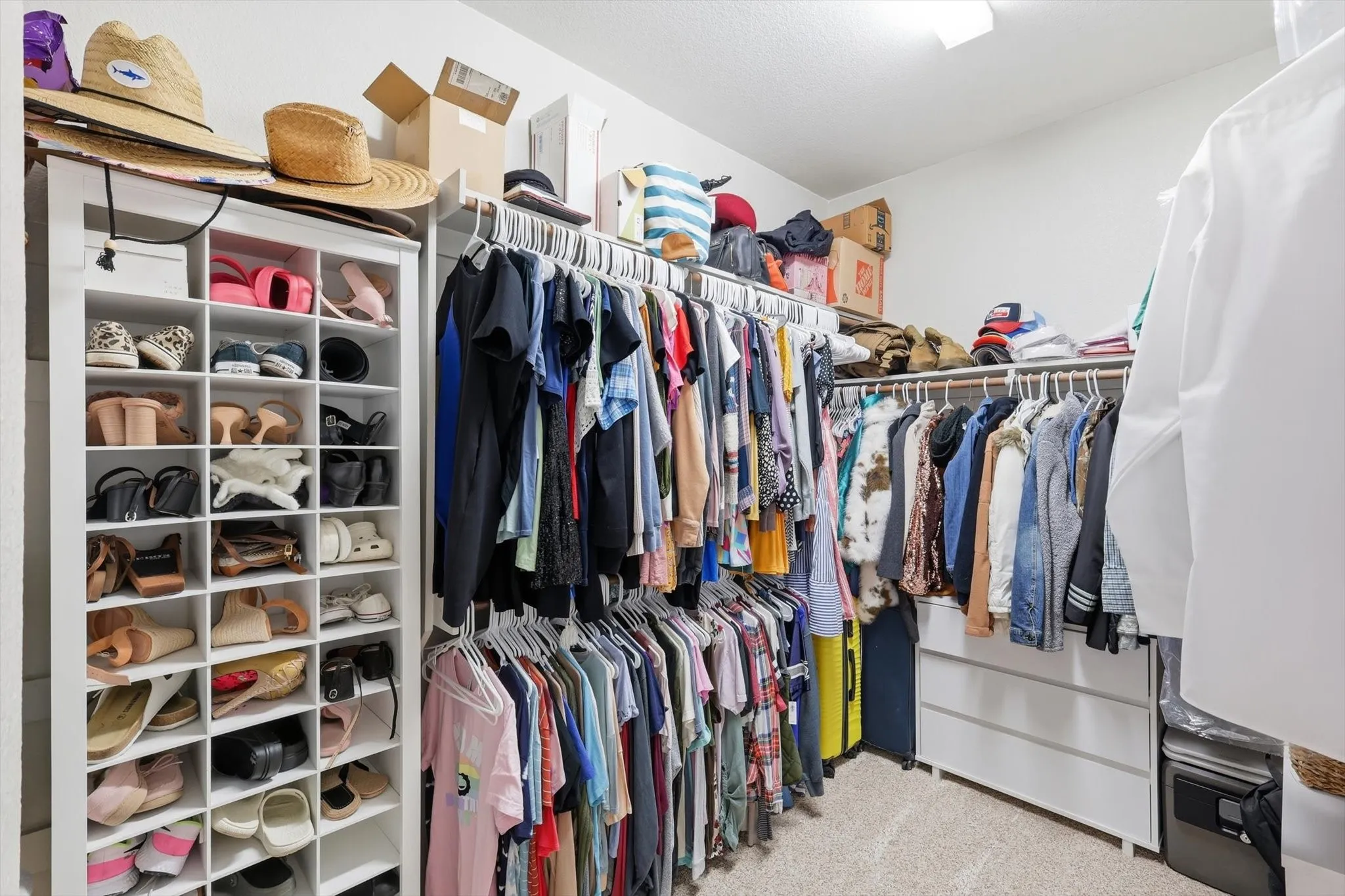 Spacious walk-in closet featuring extensive built-in shelving, multiple hanging rods, and integrated drawer storage