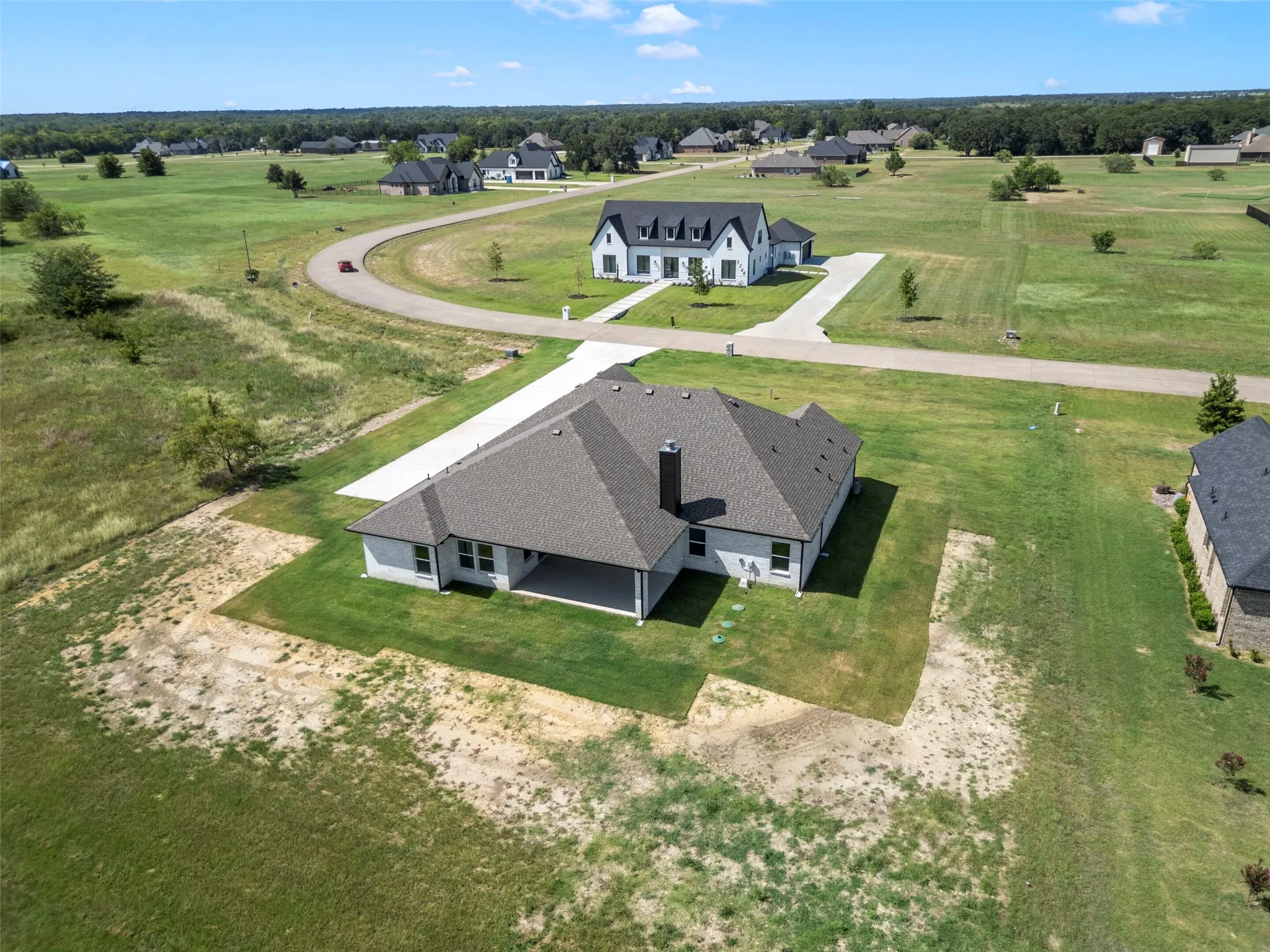New construction home with a light-colored exterior and a covered patio