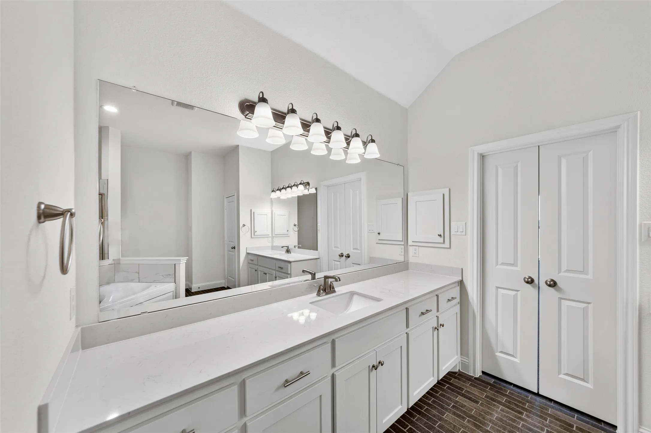 Expansive vanity featuring a white countertop, undermount sink, and brushed nickel faucet
