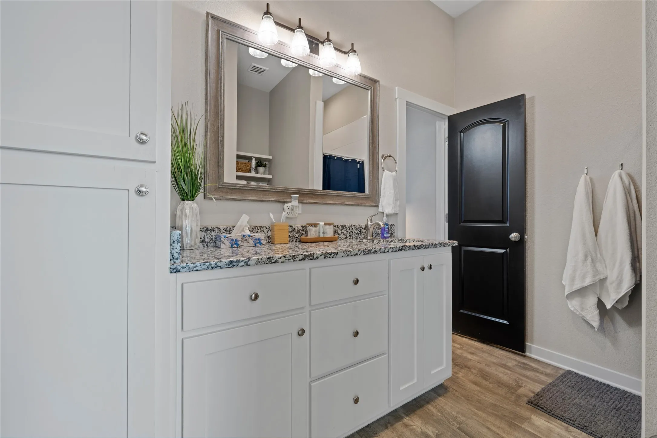Double vanity with gray-flecked countertop and dual sinks