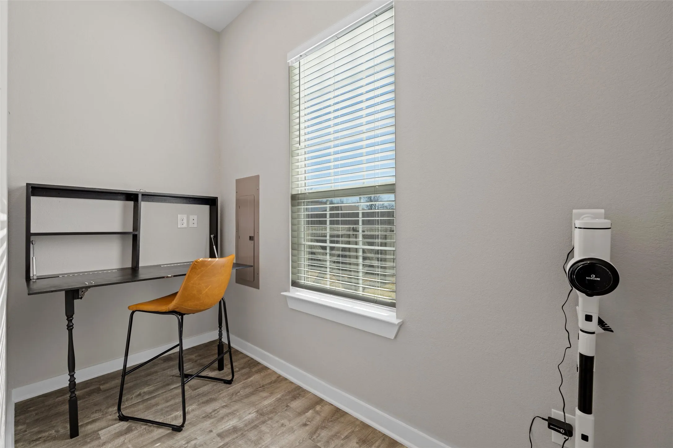 Bright room featuring wood-finish flooring and a single window with blinds