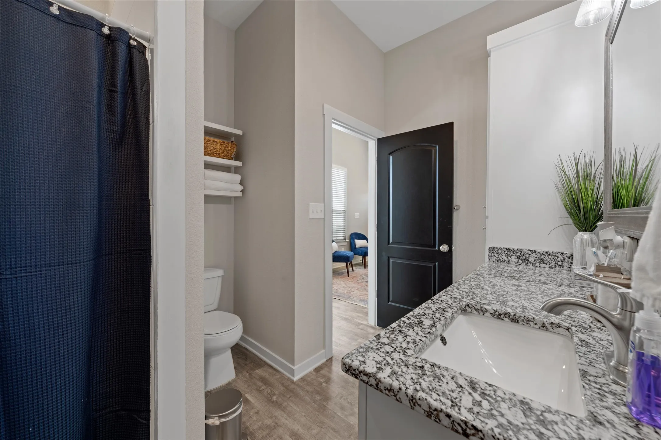 Bathroom vanity featuring a speckled countertop and an undermount sink with a brushed nickel faucet