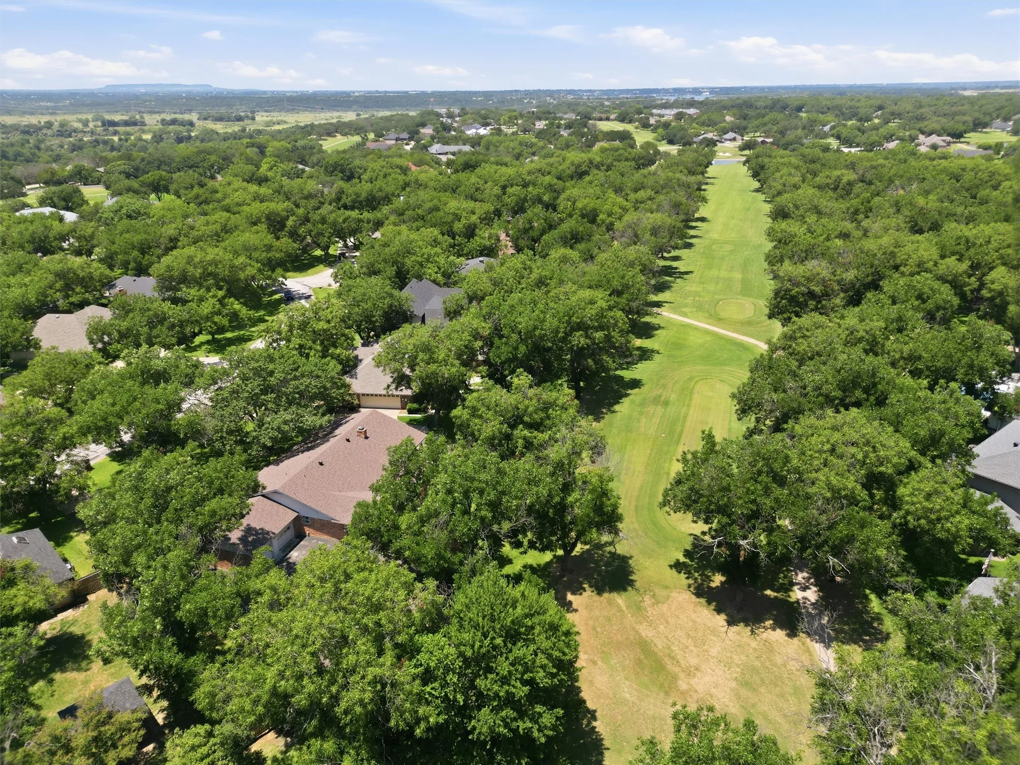 Aerial perspective showcasing a residential property surrounded by mature trees
