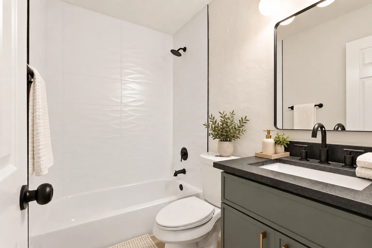Bathroom with a white bathtub, textured wall tile, and matte black fixtures