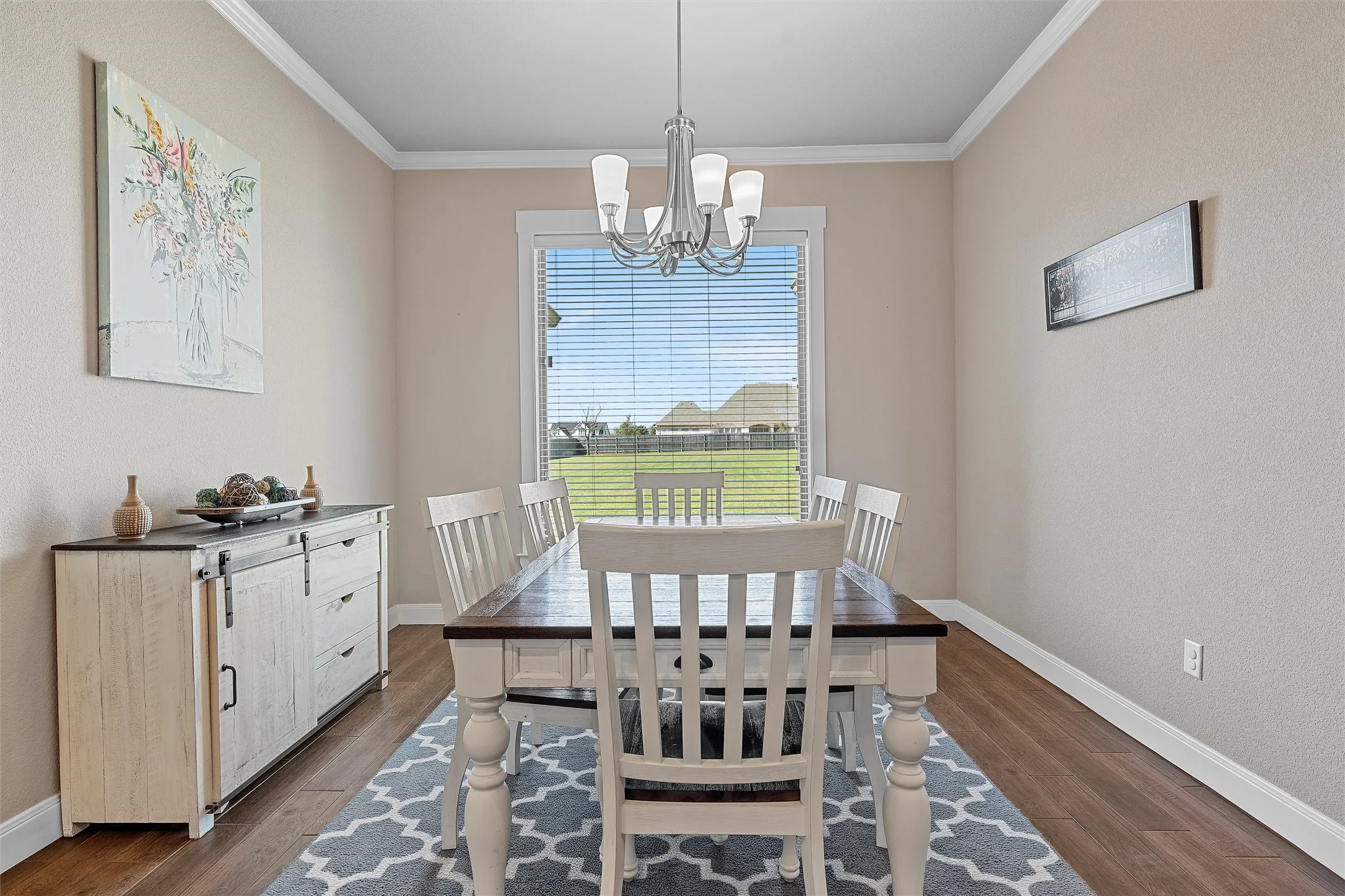 Dining area featuring wood-finish flooring, a contemporary chandelier, and a window with horizontal blinds