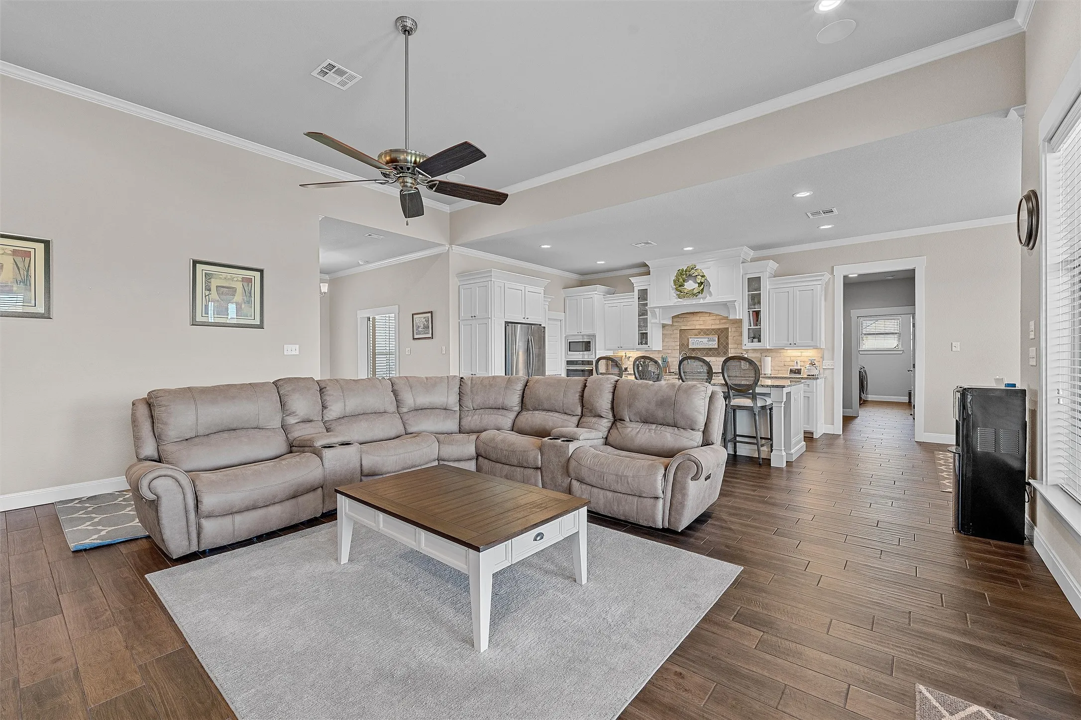 Open-concept living space featuring wood-finish flooring, a contemporary ceiling fan, and recessed lighting