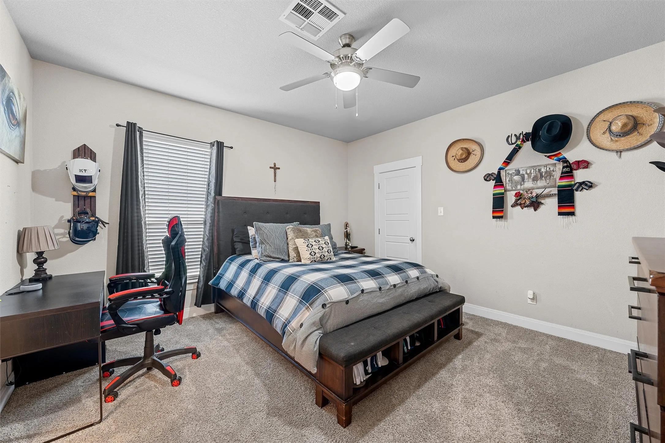 Carpeted interior space featuring a ceiling fan with integrated lighting, window with blinds and dark drapes, and a paneled interior door