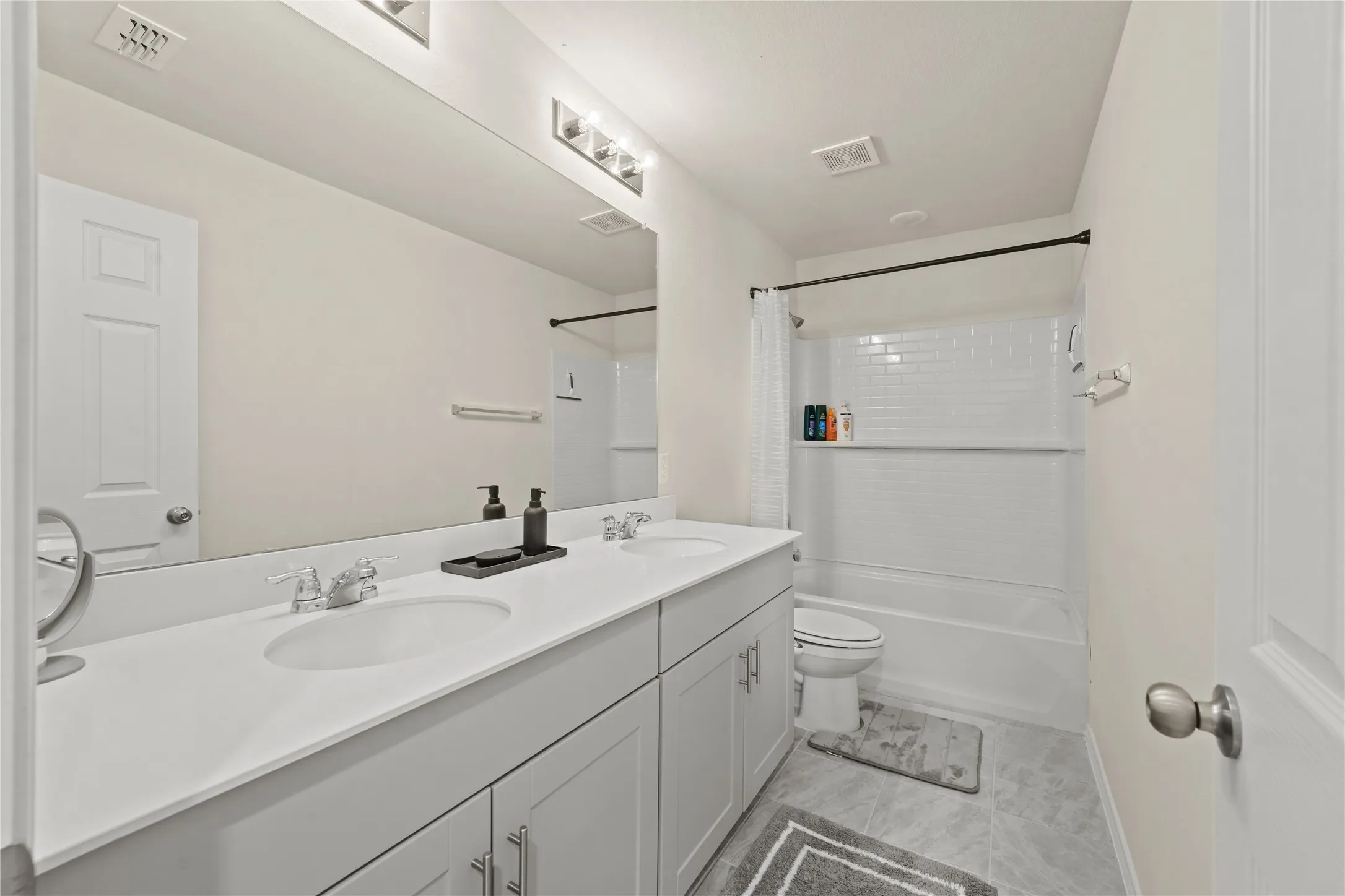 Full bathroom with vanity, toilet, and shower / bathtub combination with curtain