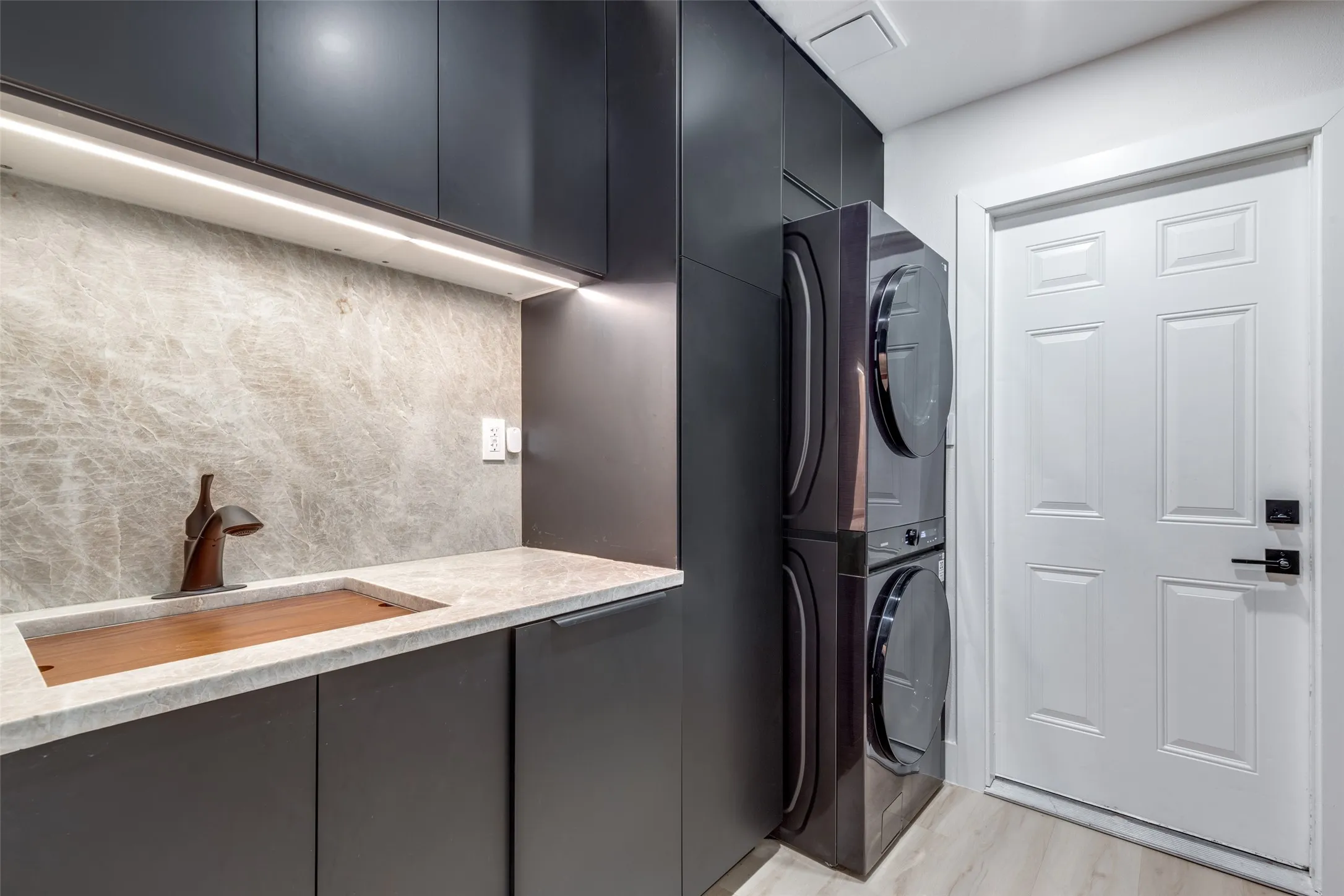 The laundry room continues on with the sleek black look, making this room somewhere you actually want to be!