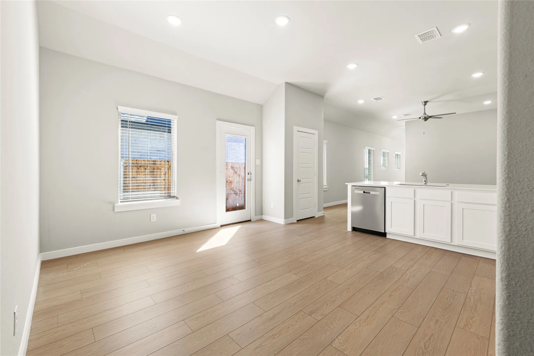 Unfurnished living room featuring sink, light hardwood / wood-style floors, and ceiling fan