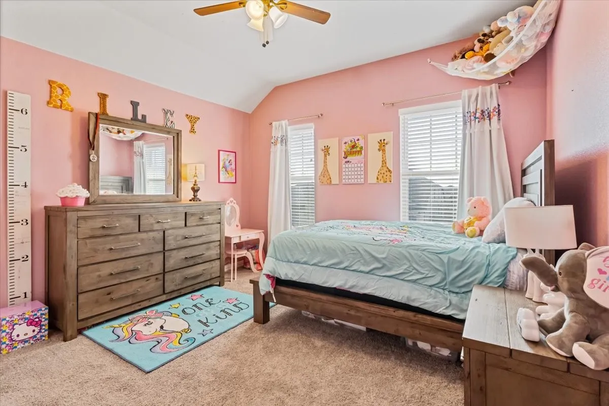 Bedroom with carpet flooring, vaulted ceiling, and ceiling fan