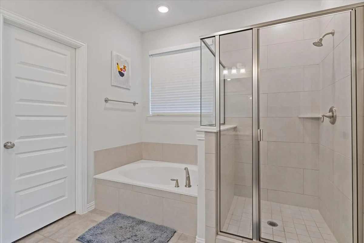 Bathroom featuring a stall shower, a bath, and tile patterned floors