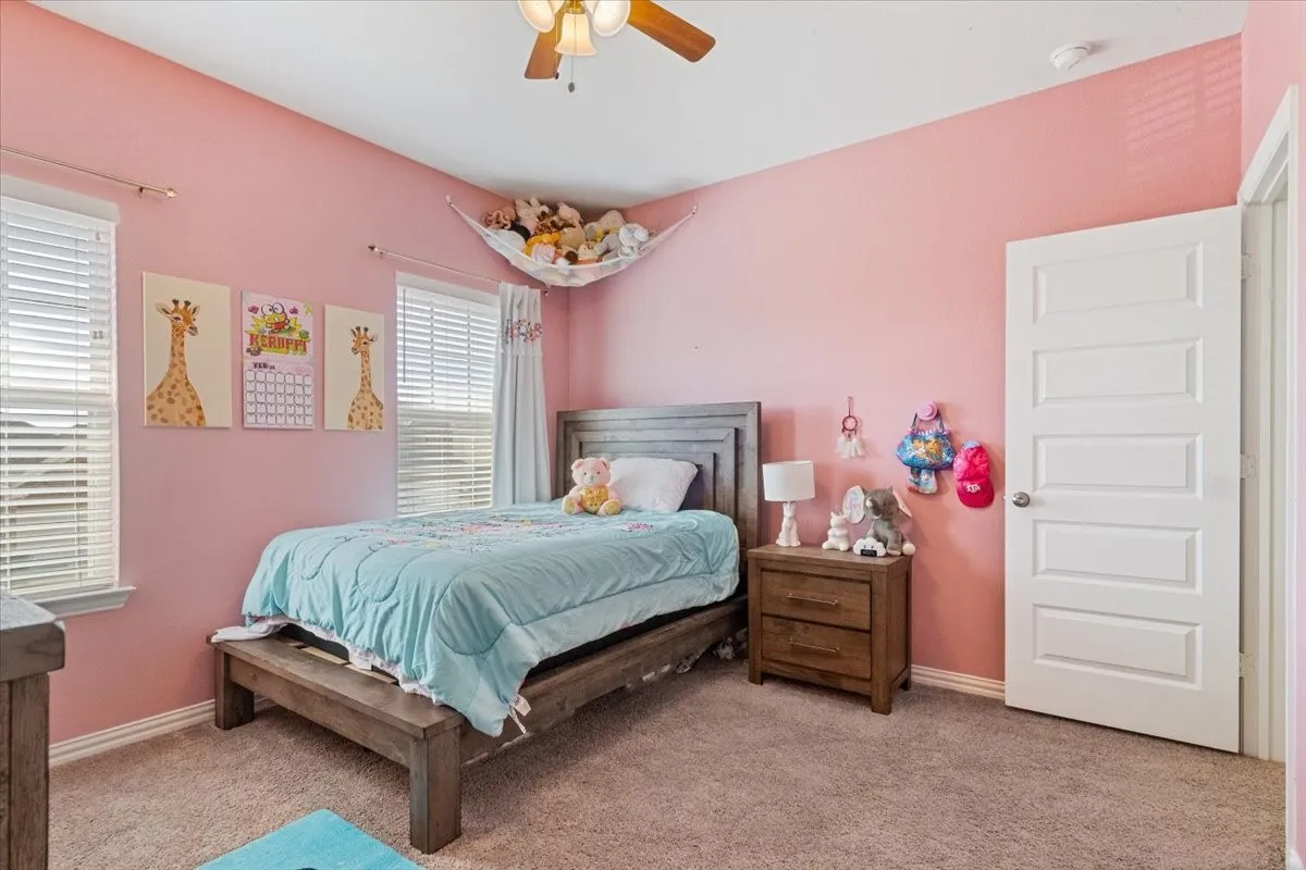 Bedroom with baseboards, a ceiling fan, and light colored carpet