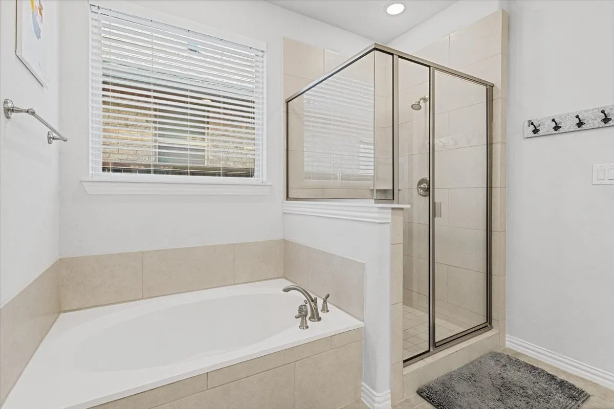 Bathroom with a shower stall, a bath, and recessed lighting