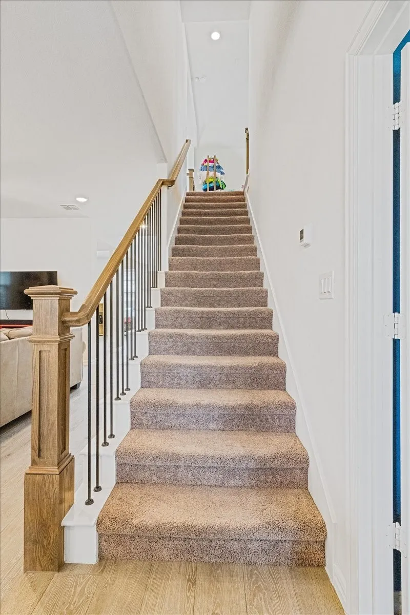 Staircase with recessed lighting, baseboards, and wood finished floors
