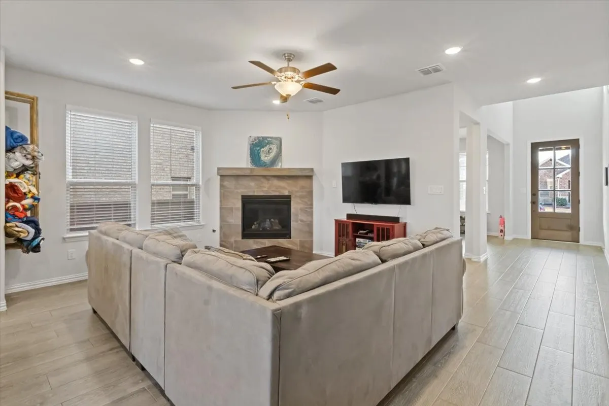 Living area with light wood-type flooring, a fireplace, visible vents, and recessed lighting