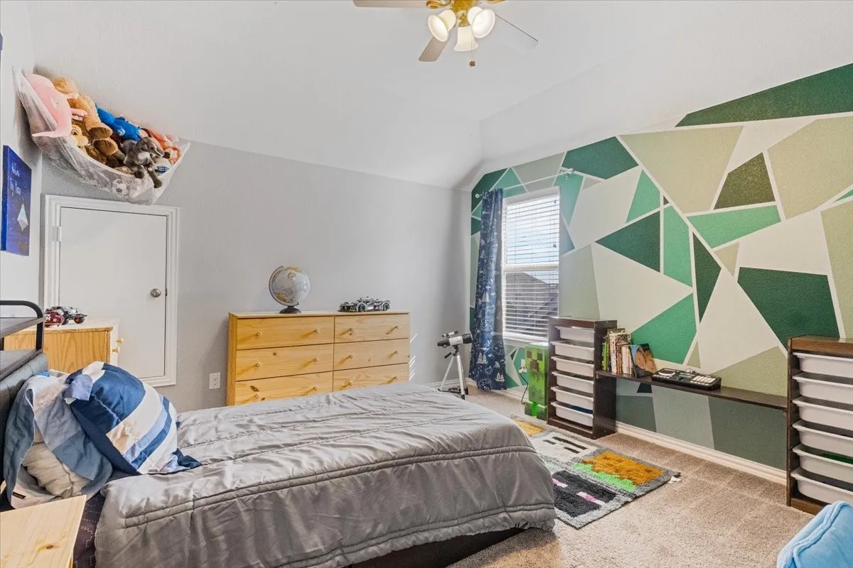 Bedroom featuring lofted ceiling, carpet flooring, ceiling fan, and baseboards