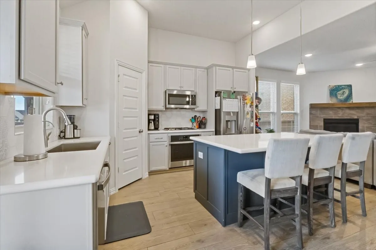 Kitchen featuring white cabinetry, stainless steel appliances, a sink, and light countertops