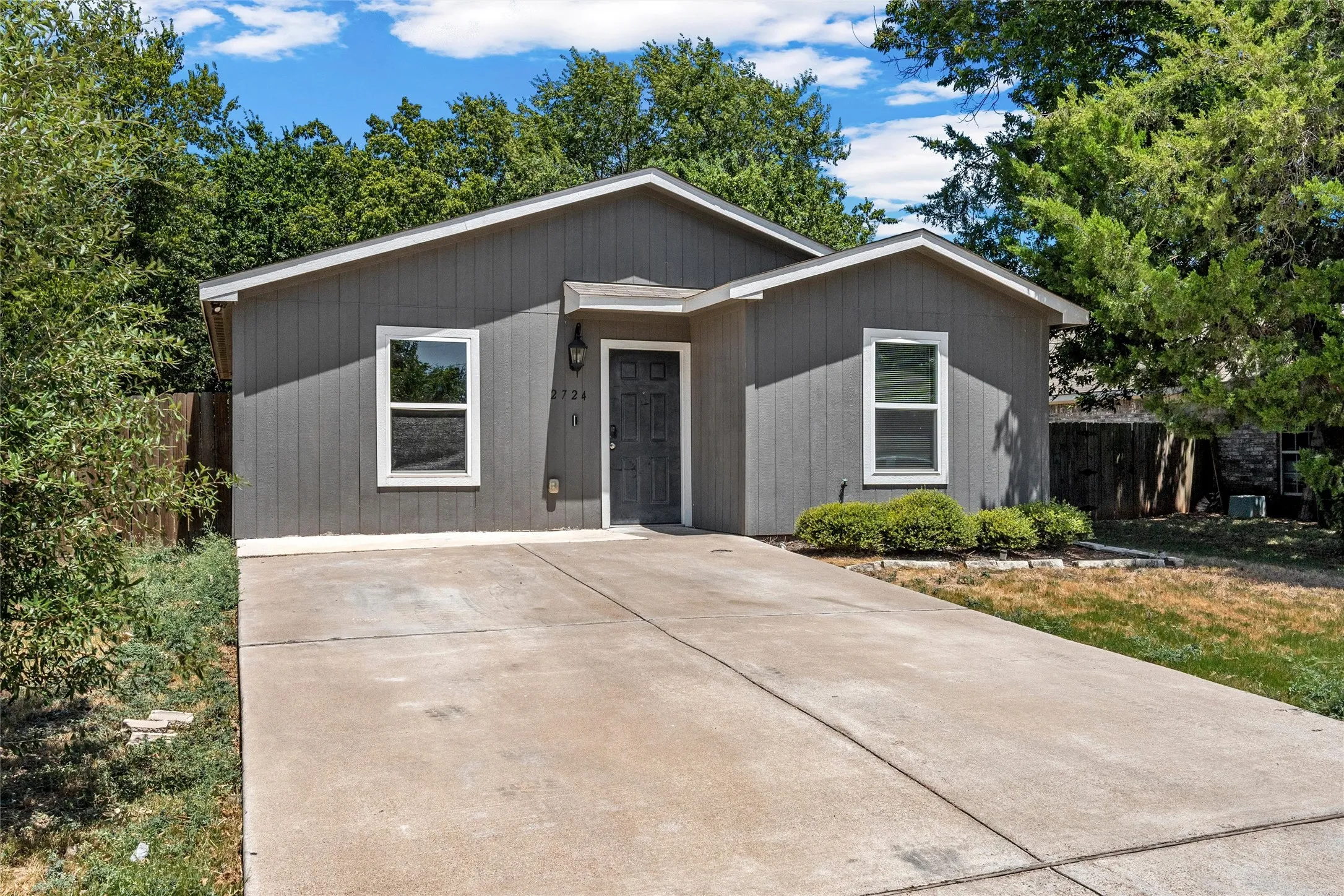 Single-story residence featuring a gray exterior siding and a matching gray entry door