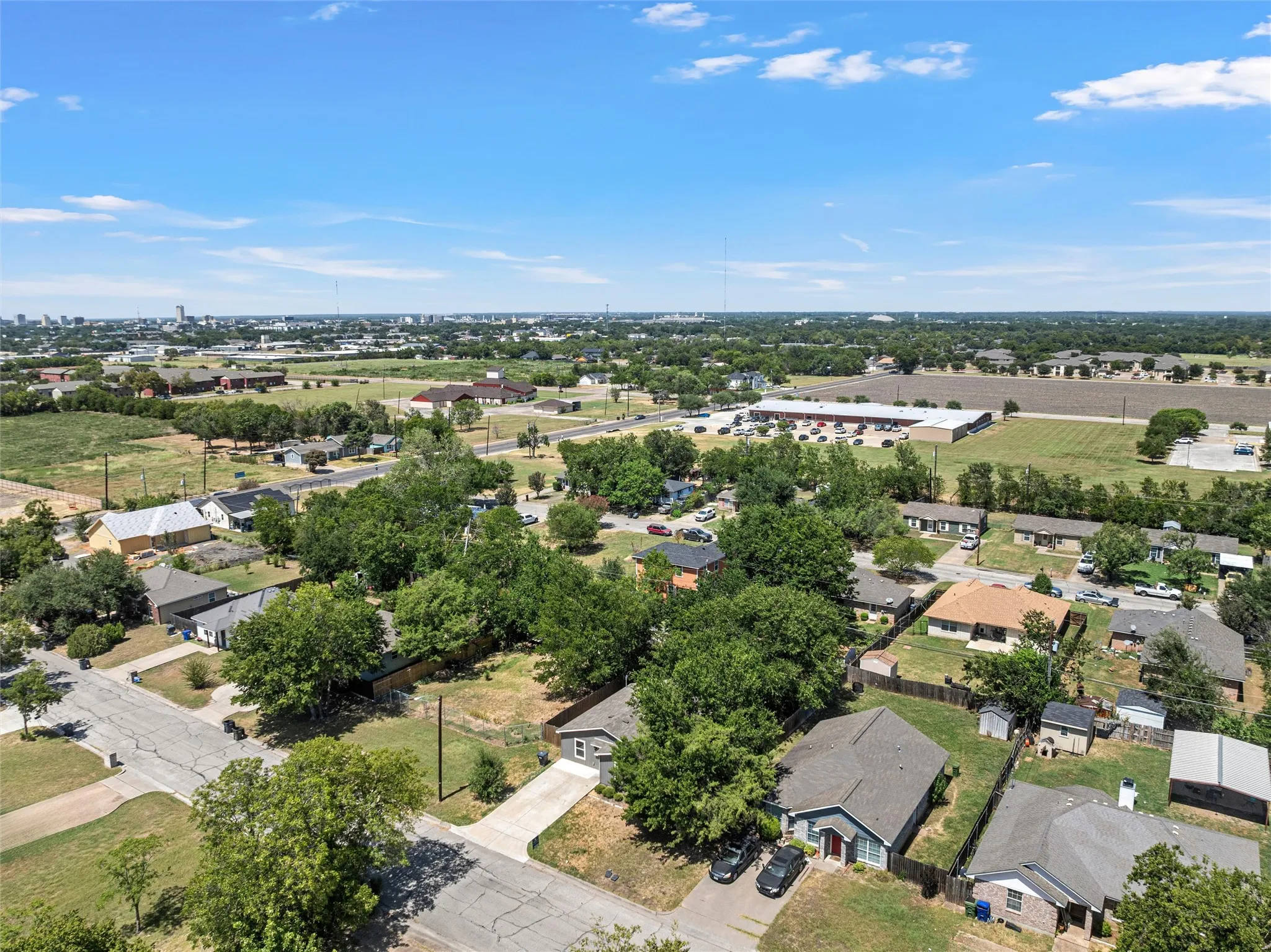 Aerial view showcasing this residential property situated on a generous lot with mature trees providing natural landscaping