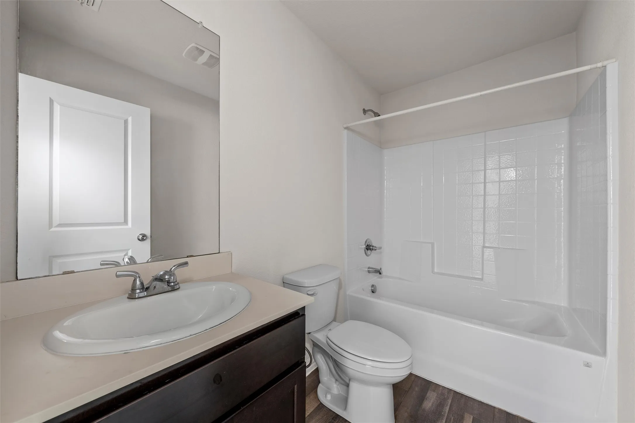 Vanity with a single basin sink, chrome faucet, and dark wood-finish cabinetry