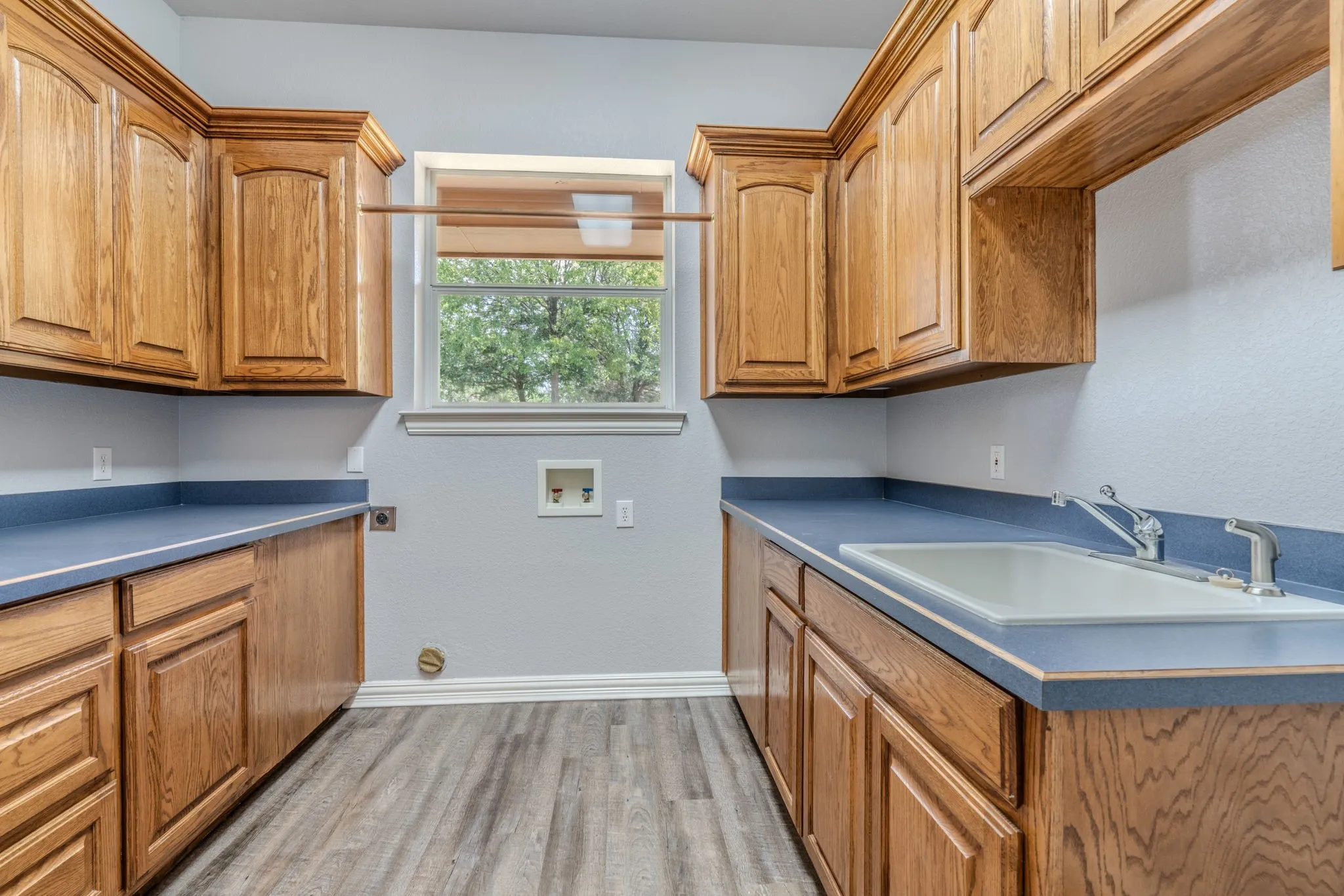 Tons of space in this laundry room with room for a refrigerator. Look at all that storage space and sink!
