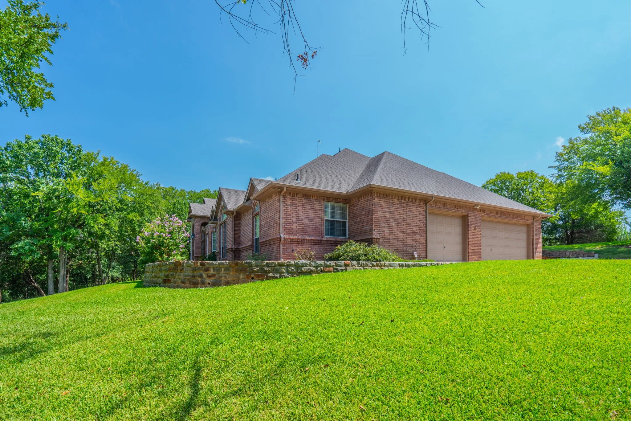 View of the house from the yard, featuring the 3-car garage.