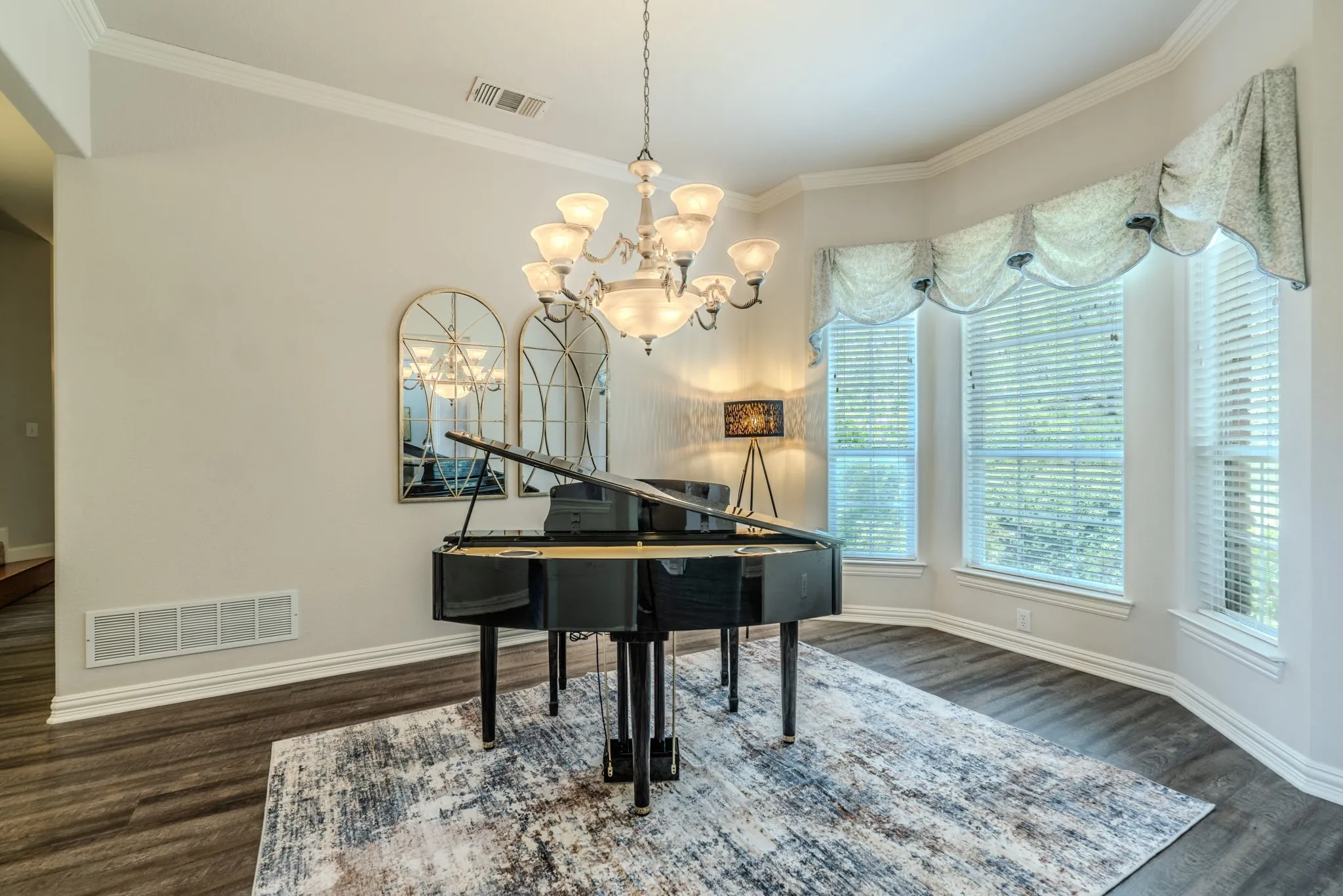 Formal dining room with bay windows and decorative lighting-currently being used as an entertainment area with piano.