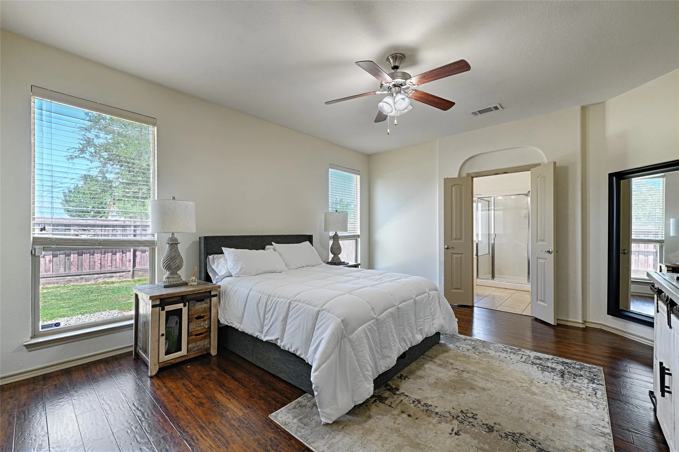 Spacious bedroom featuring wood-finish flooring and a ceiling fan