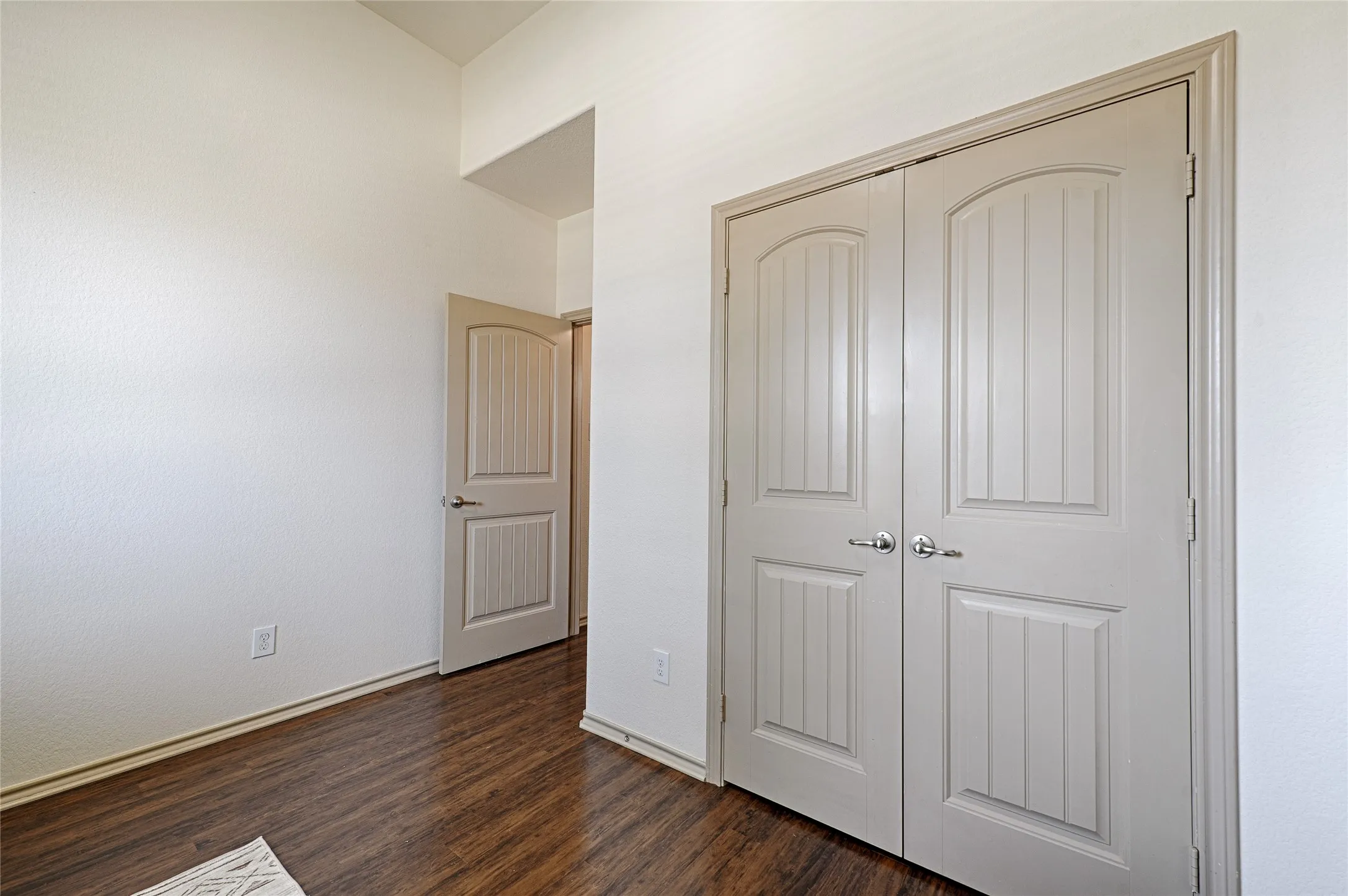 Warm wood-finish flooring complements the crisp white walls and light-toned interior doors with brushed nickel hardware