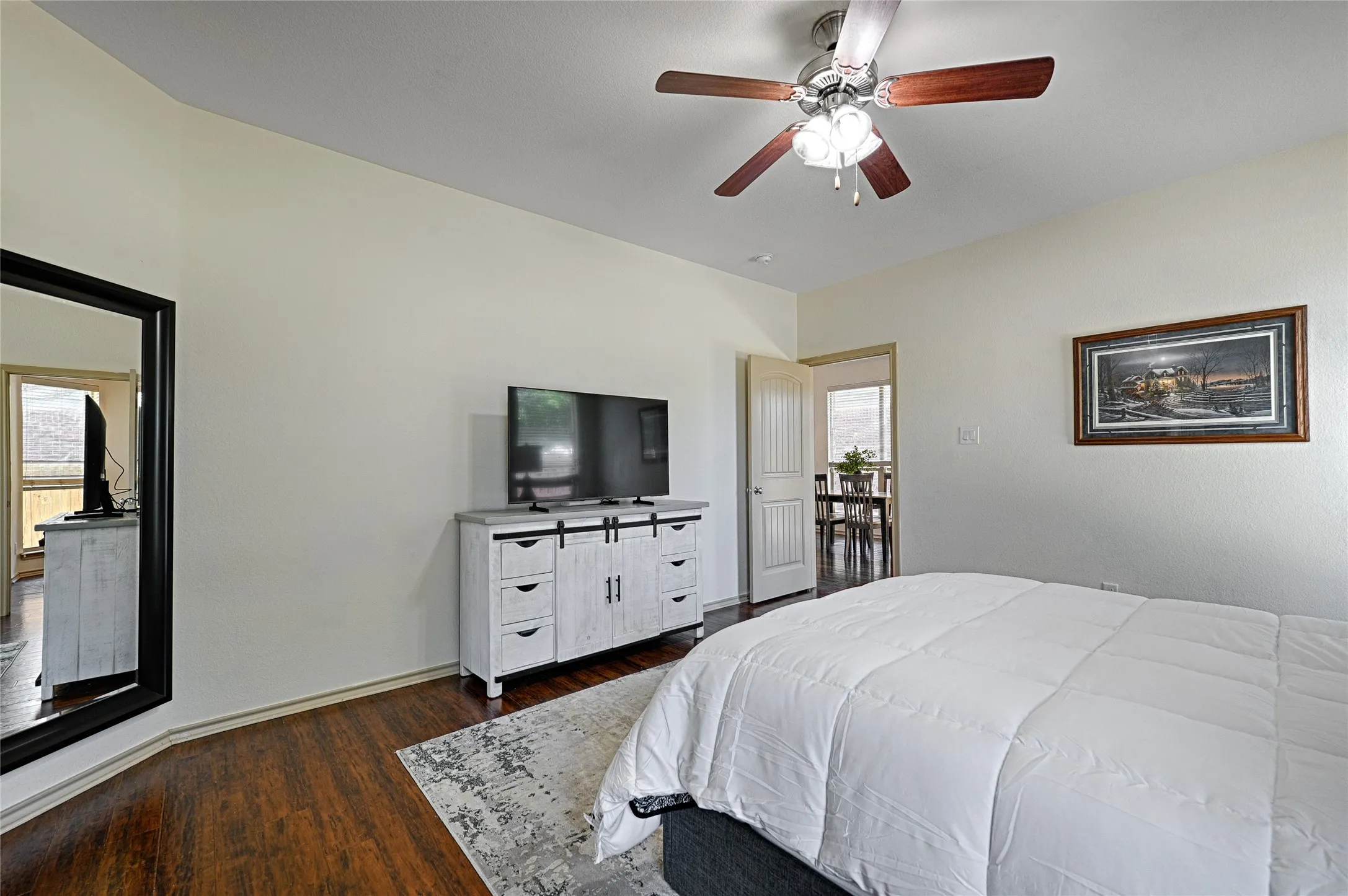 Interior room featuring wood-finish flooring, light-toned walls, and a ceiling fan with integrated lighting