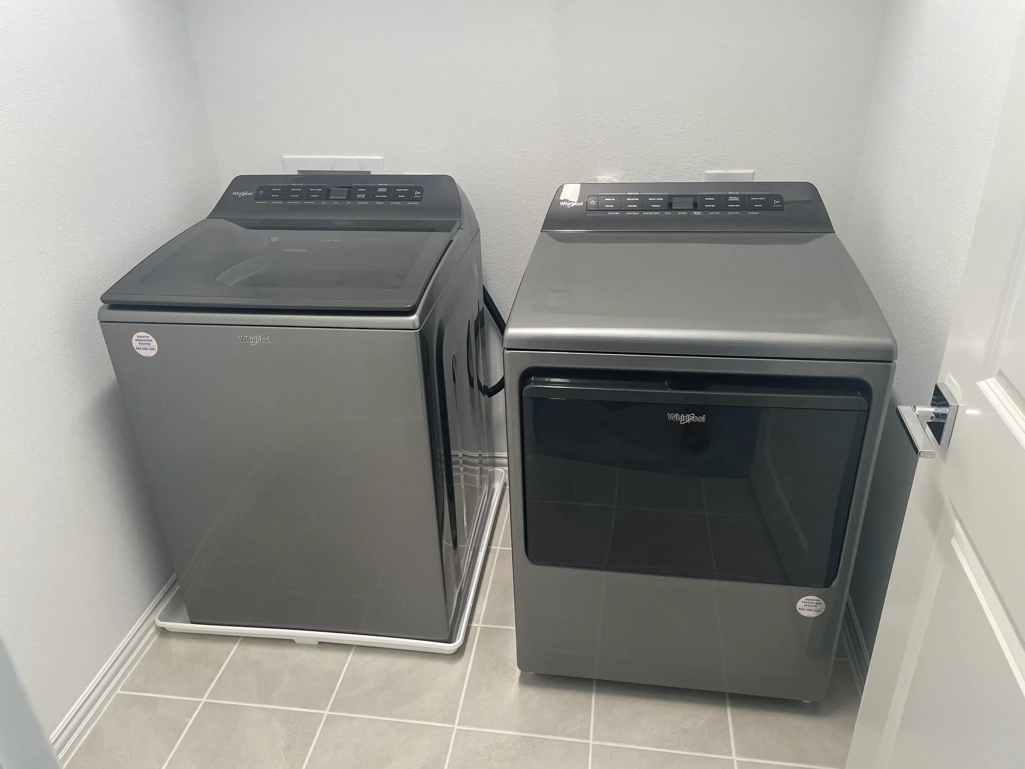 Dedicated laundry area featuring a top-load washer and front-load dryer in a neutral finish