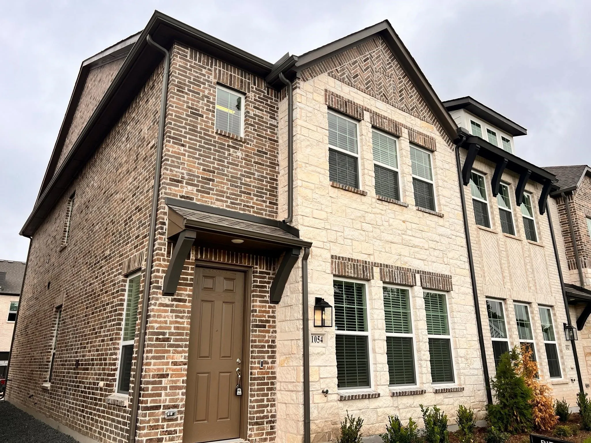 Multi-story townhome featuring a stone and brick facade