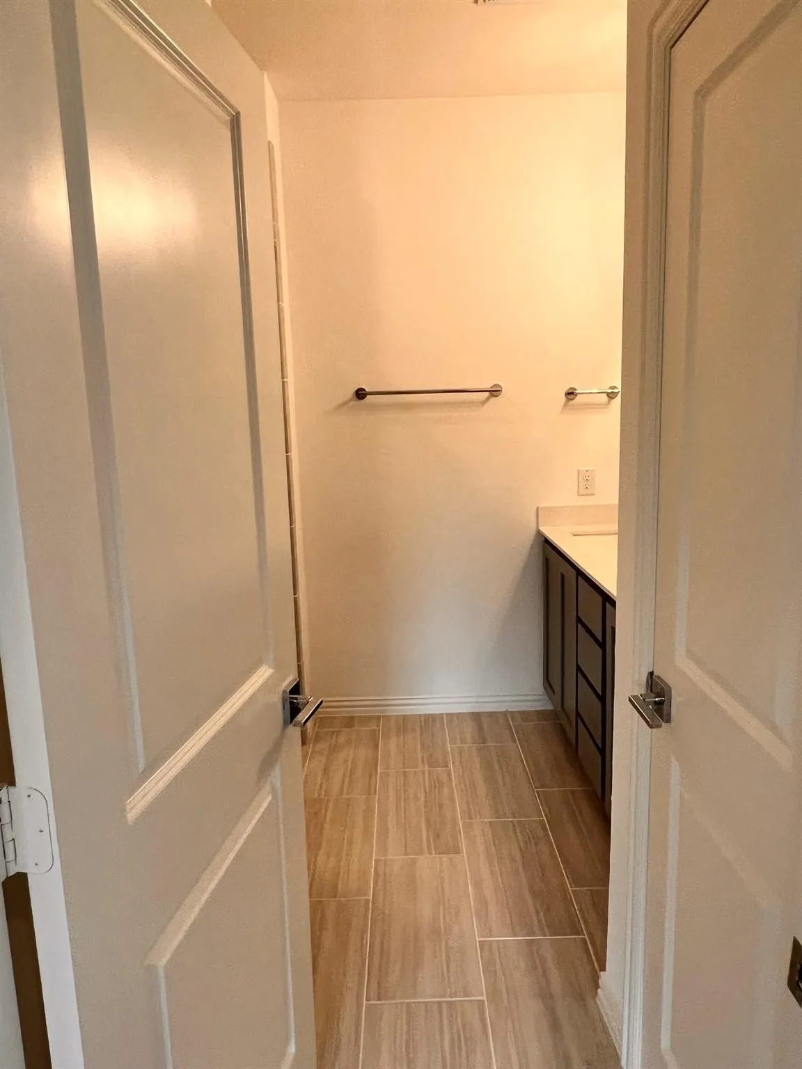 Neutral-toned ceramic tile flooring, white baseboards, and light wall finishes