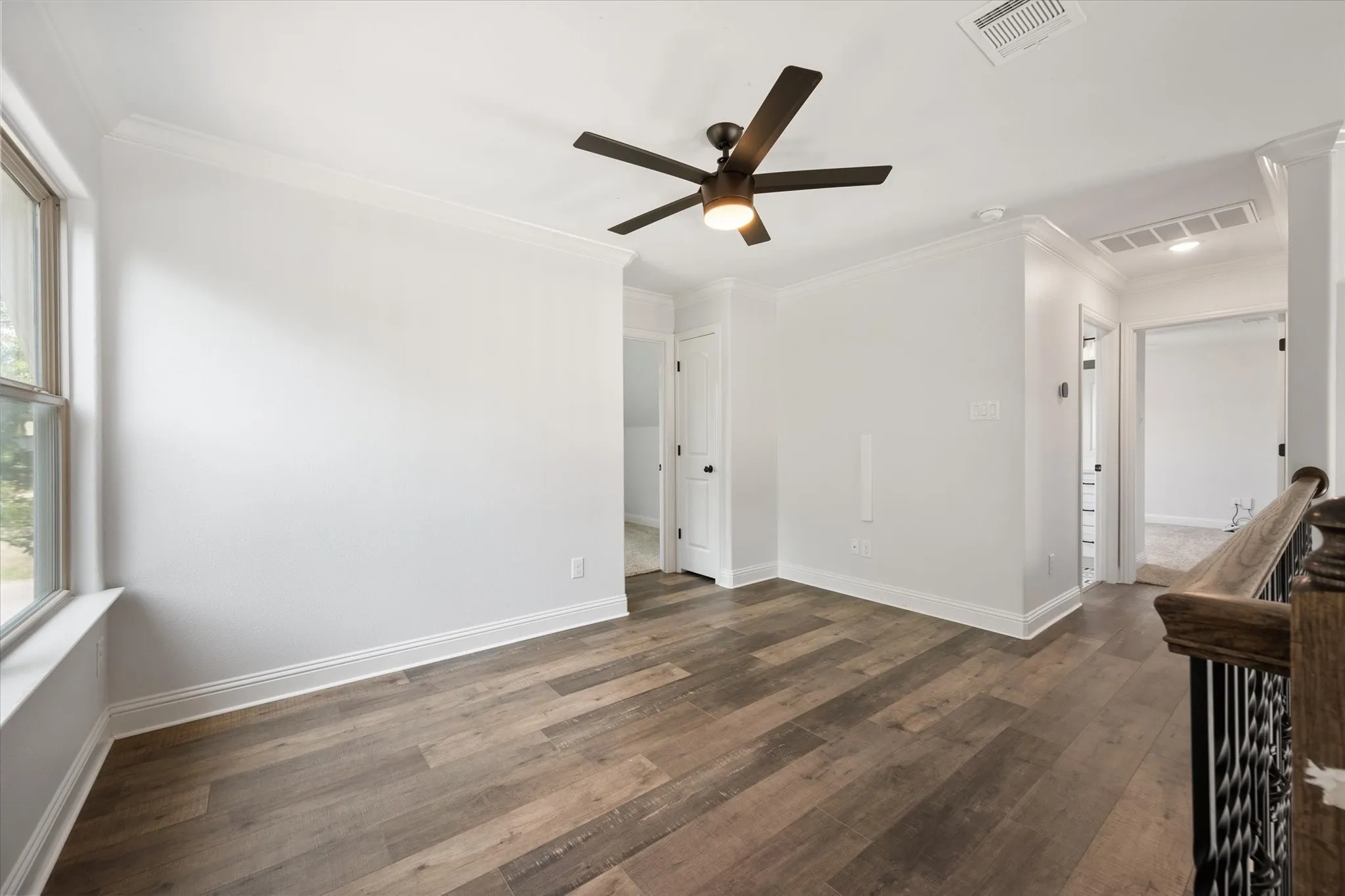 At the top of the stairs is the second living area with ceiling fan, linen closet and access to the secondary bedrooms and second full bathroom