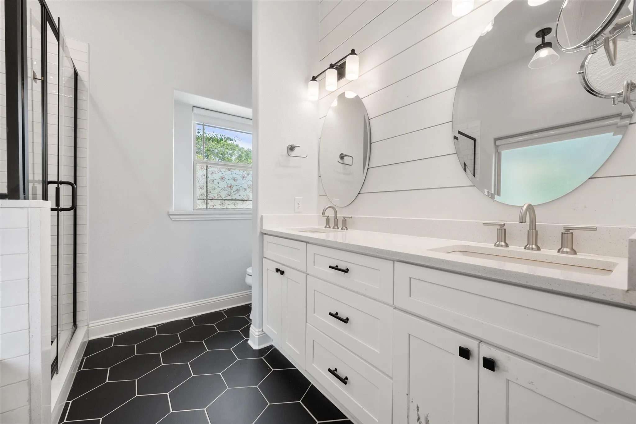 Double vanity featuring quartz countertops with integrated sinks, attractive tile flooring plus tub and separate shower!