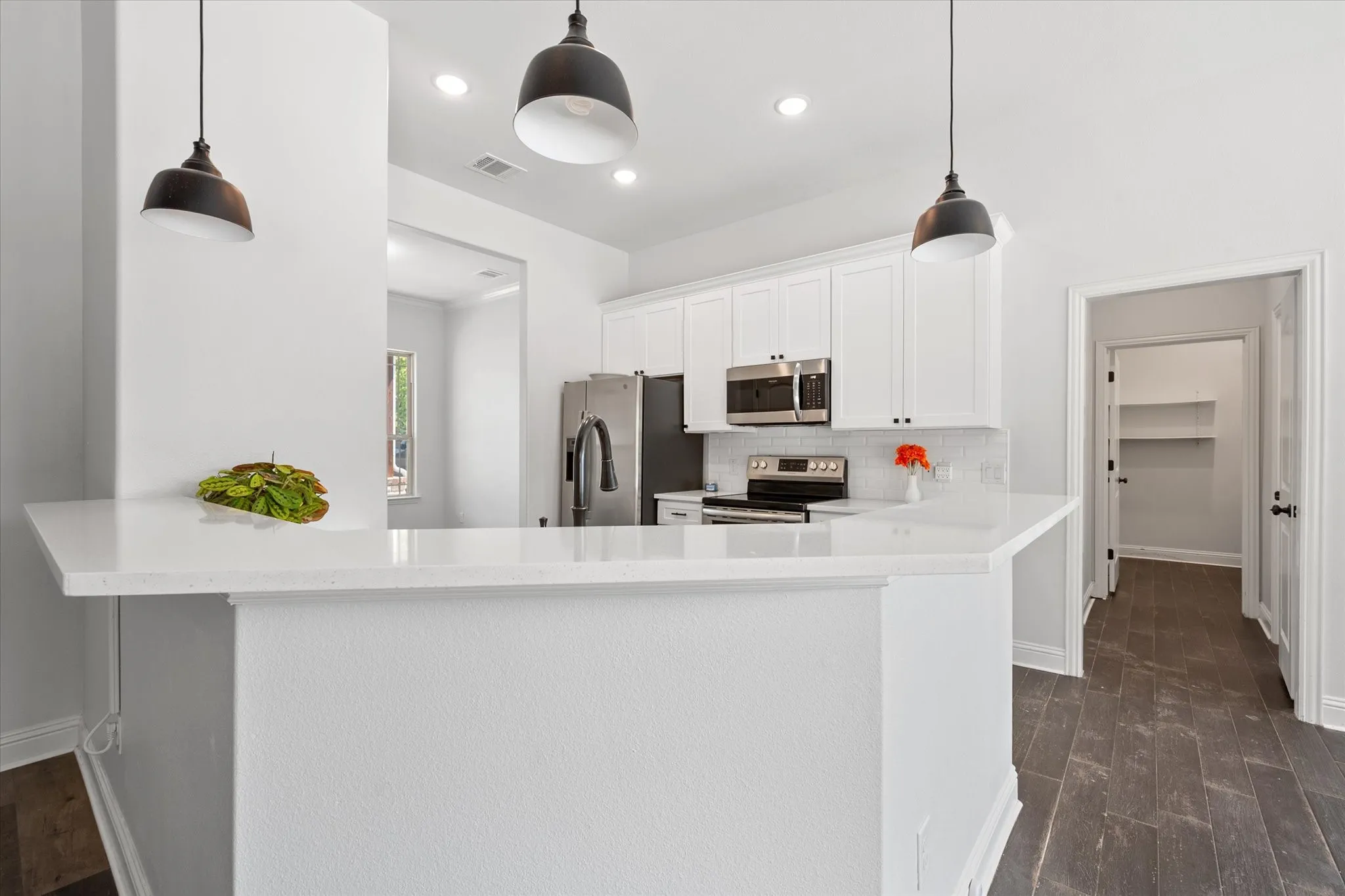 Kitchen also features a breakfast bar overlooking the living area and pendant lighting