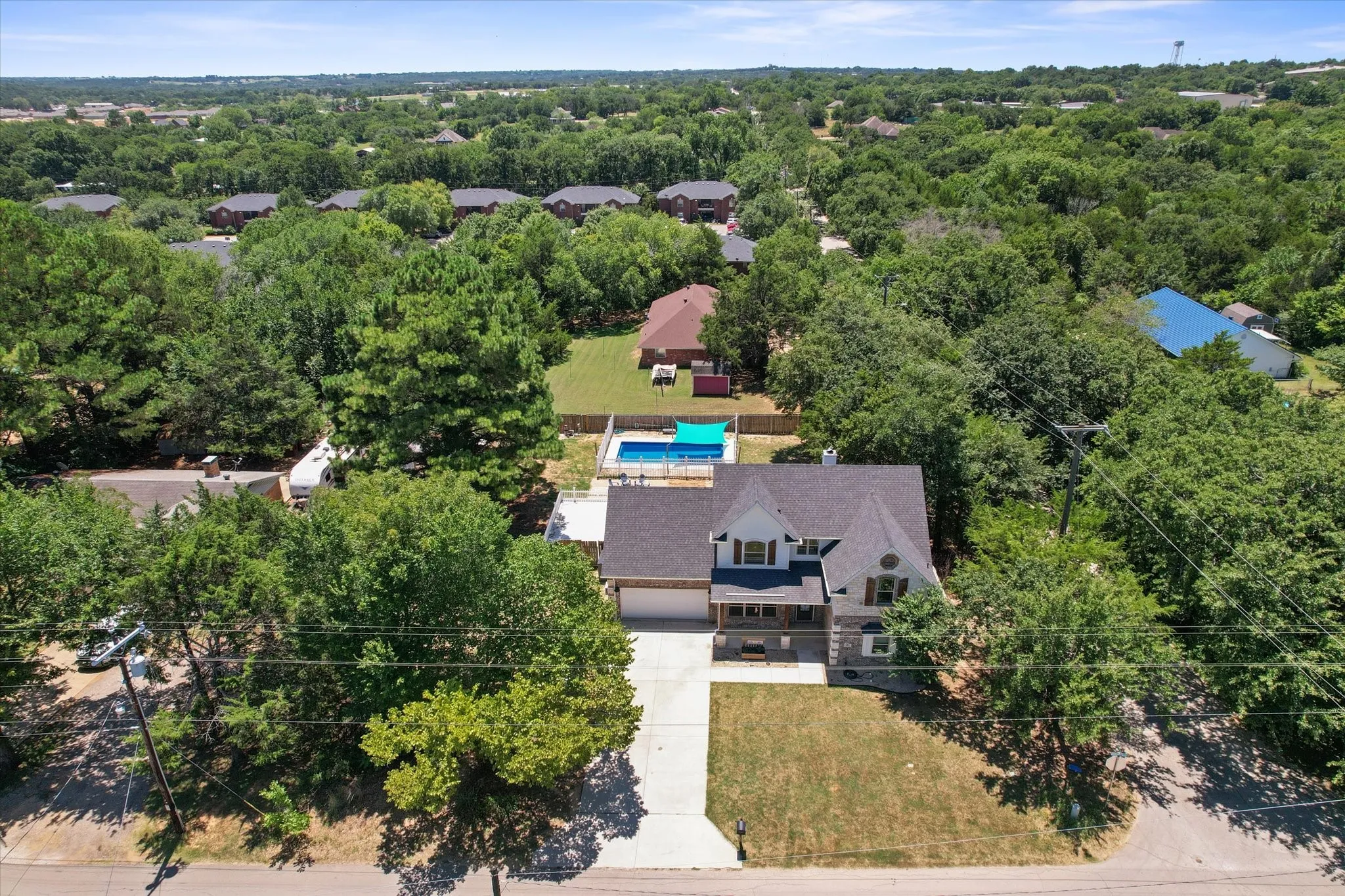 Wooded half acre lot featuring a two-story residence, an attached garage and a private separately fenced swimming pool