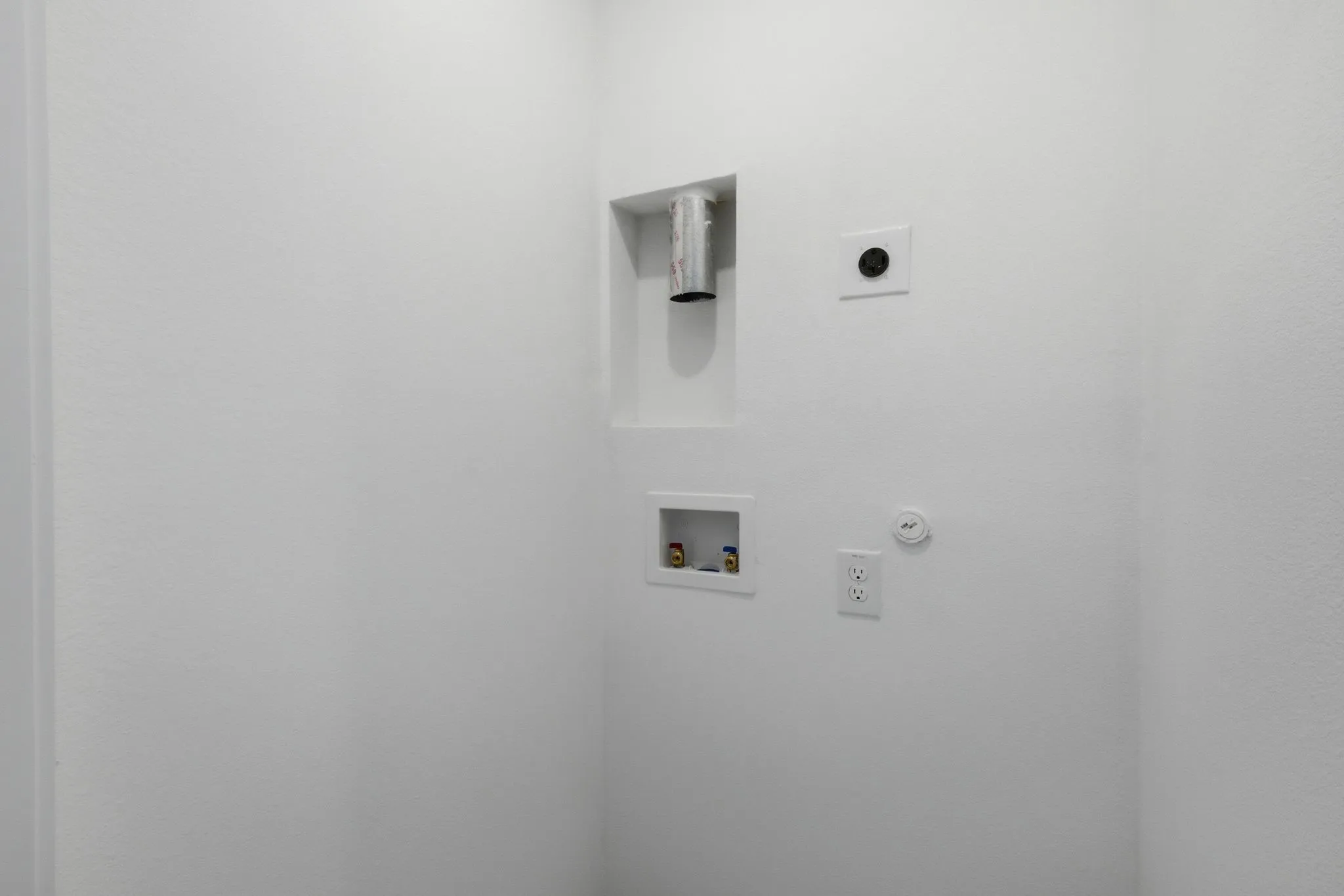 Dedicated laundry area featuring a recessed dryer vent, washer hookups, and electrical outlets