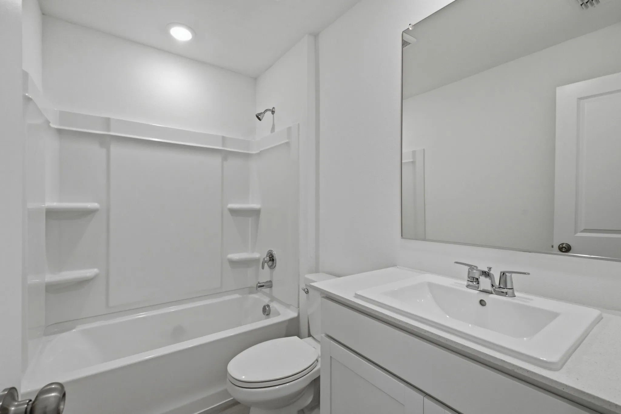 Bathroom featuring a white vanity with an integrated sink, silver-toned faucet, and a large wall-mounted mirror