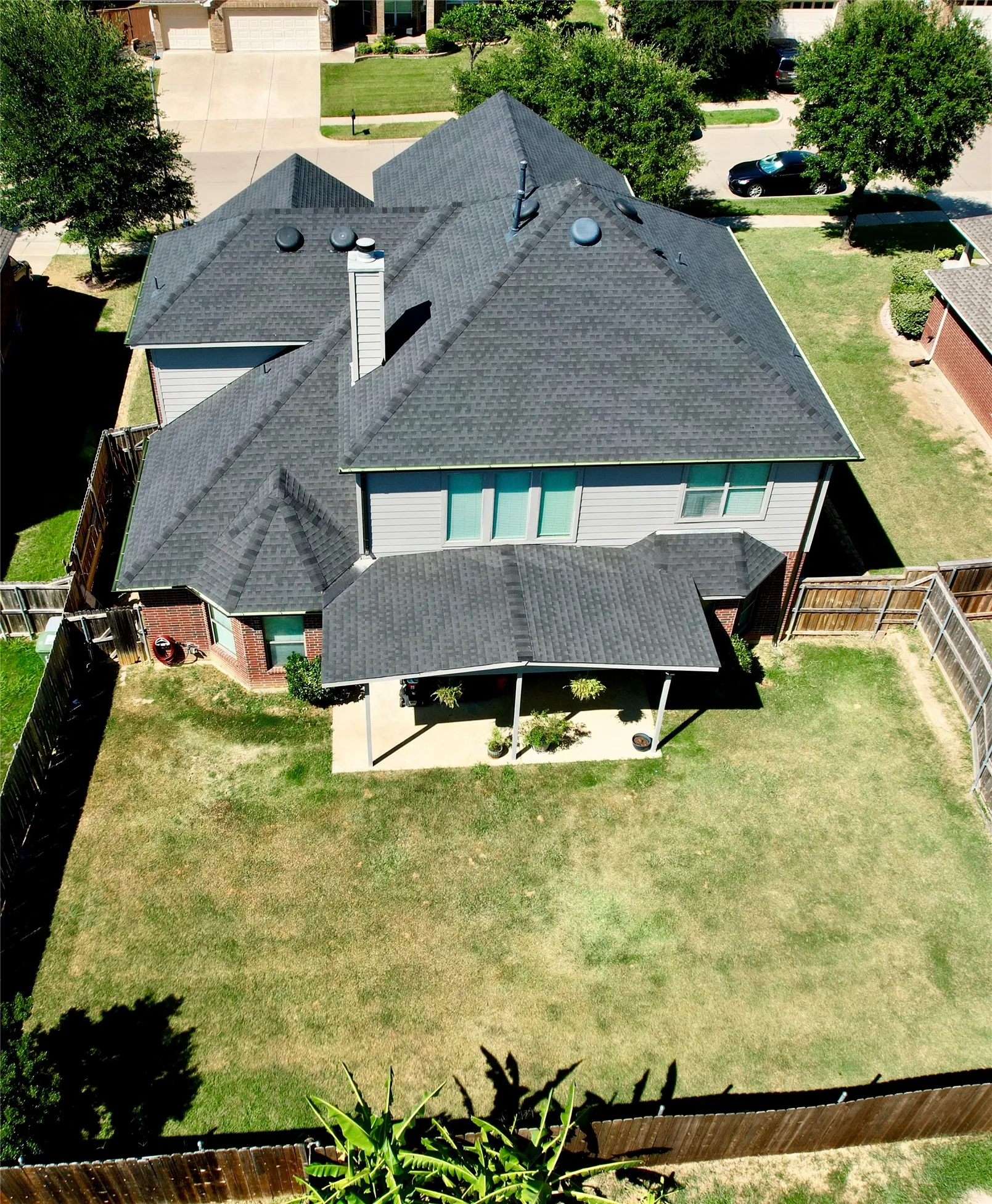Expansive fenced backyard with a covered patio
