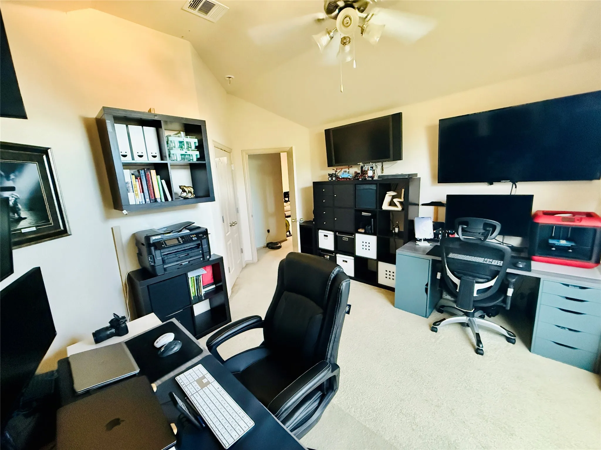 Carpeted room with a vaulted ceiling and a ceiling fan