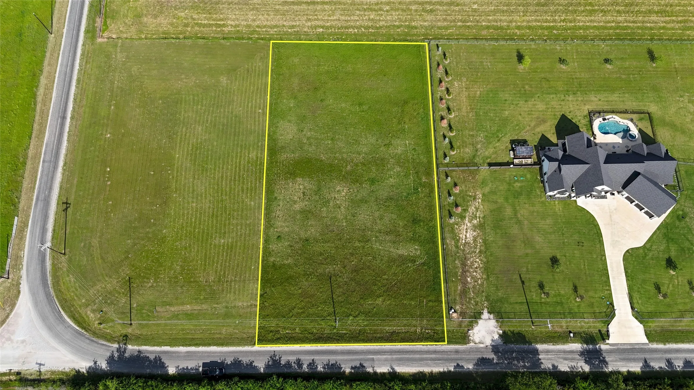 Expansive undeveloped lot featuring a grass expanse and direct road frontage