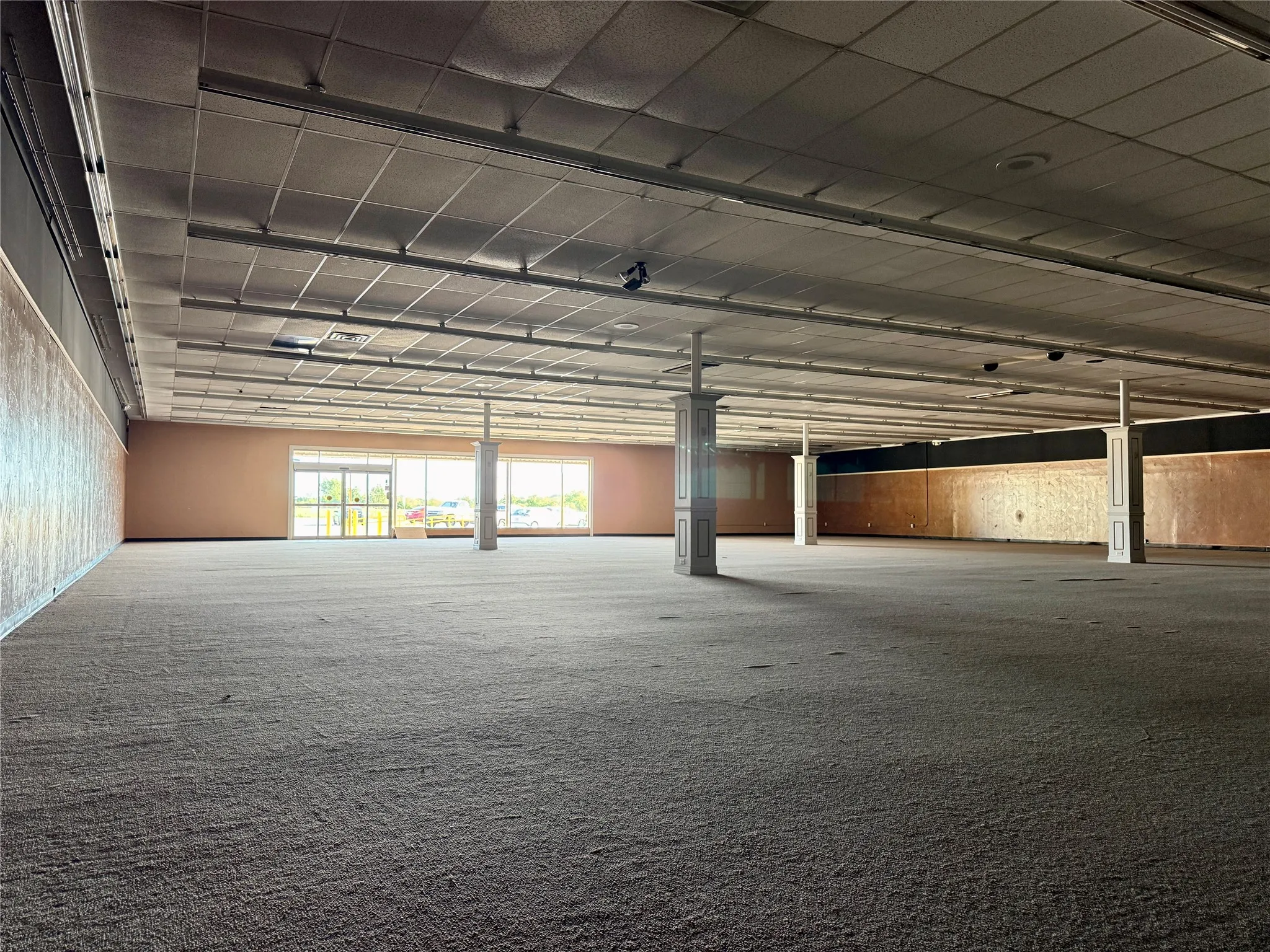Expansive commercial interior featuring gray carpeting throughout