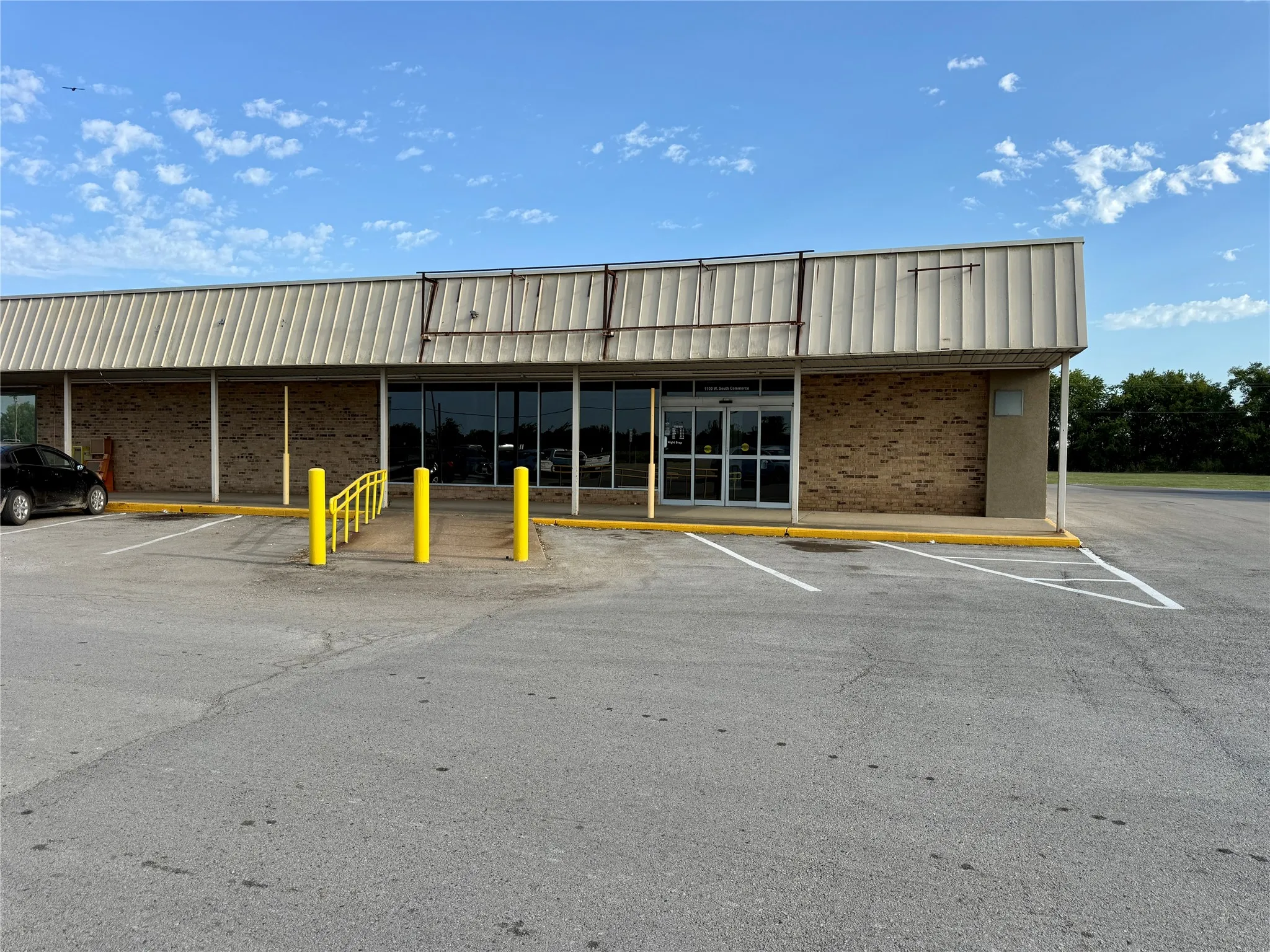 Commercial building featuring a brick facade and a metal roof