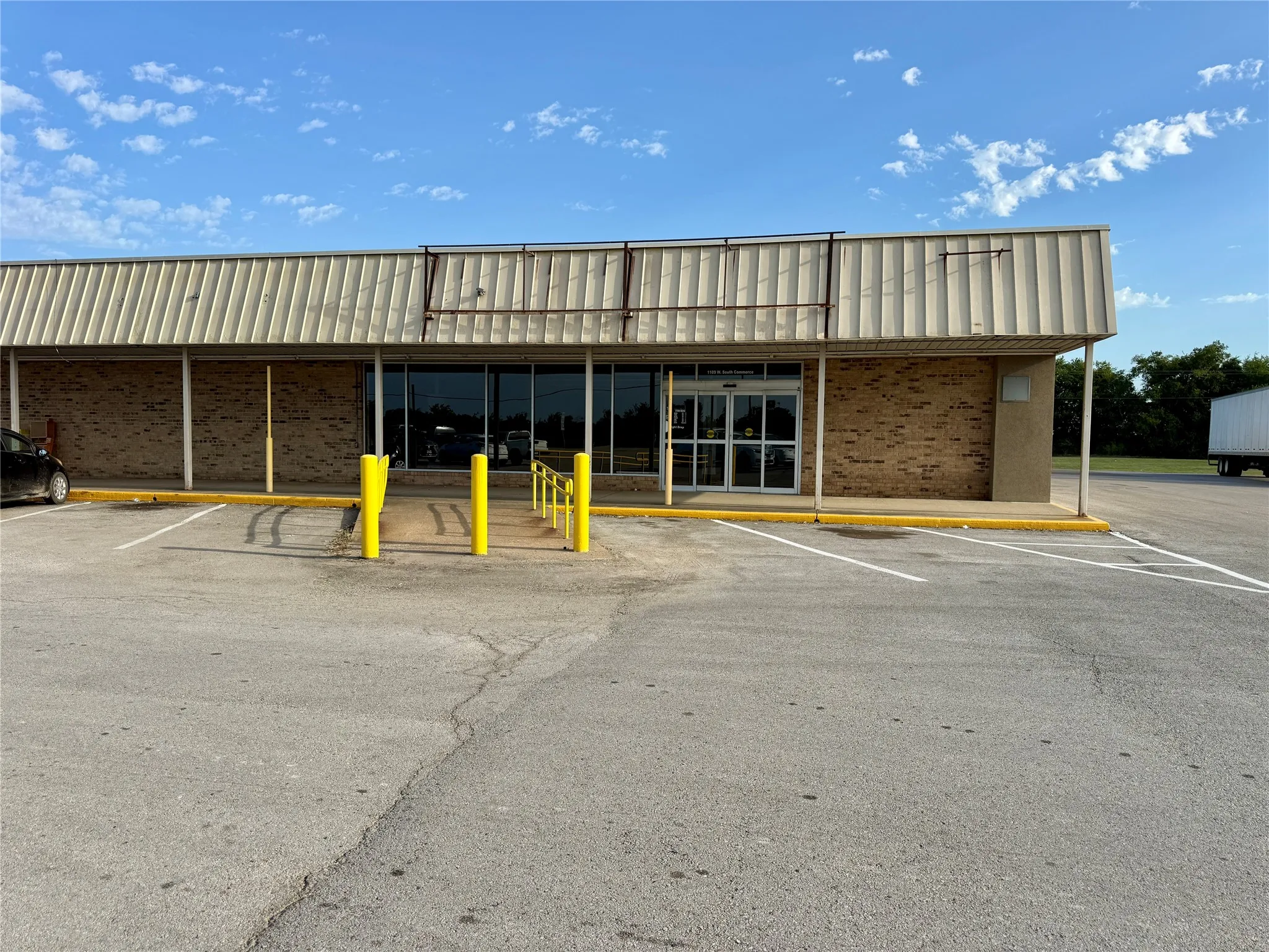 Commercial building featuring a brick facade and a wide metal canopy