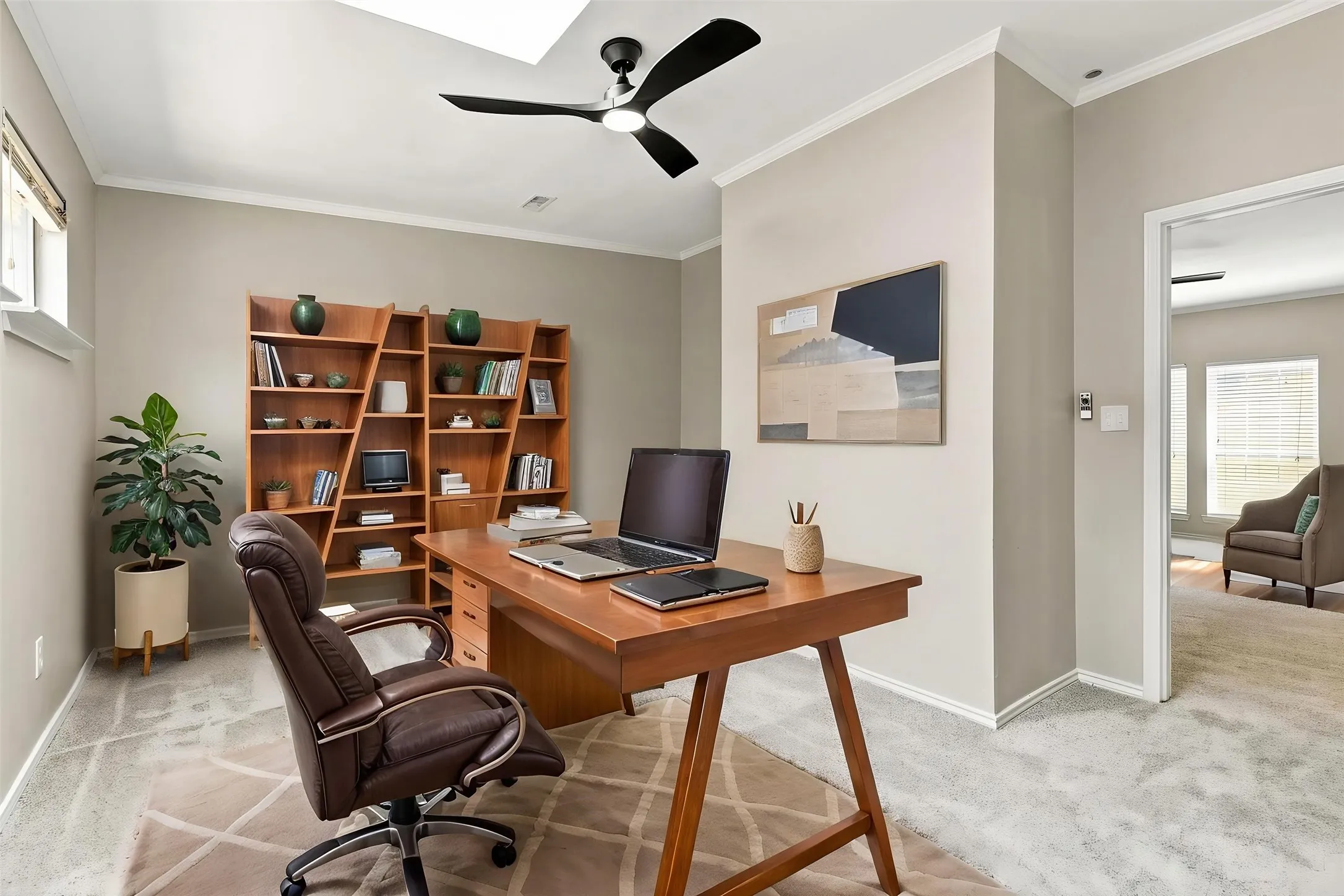 Recessed lighting, crown molding, a ceiling fan, wood-finish built-in shelving, and a skylight