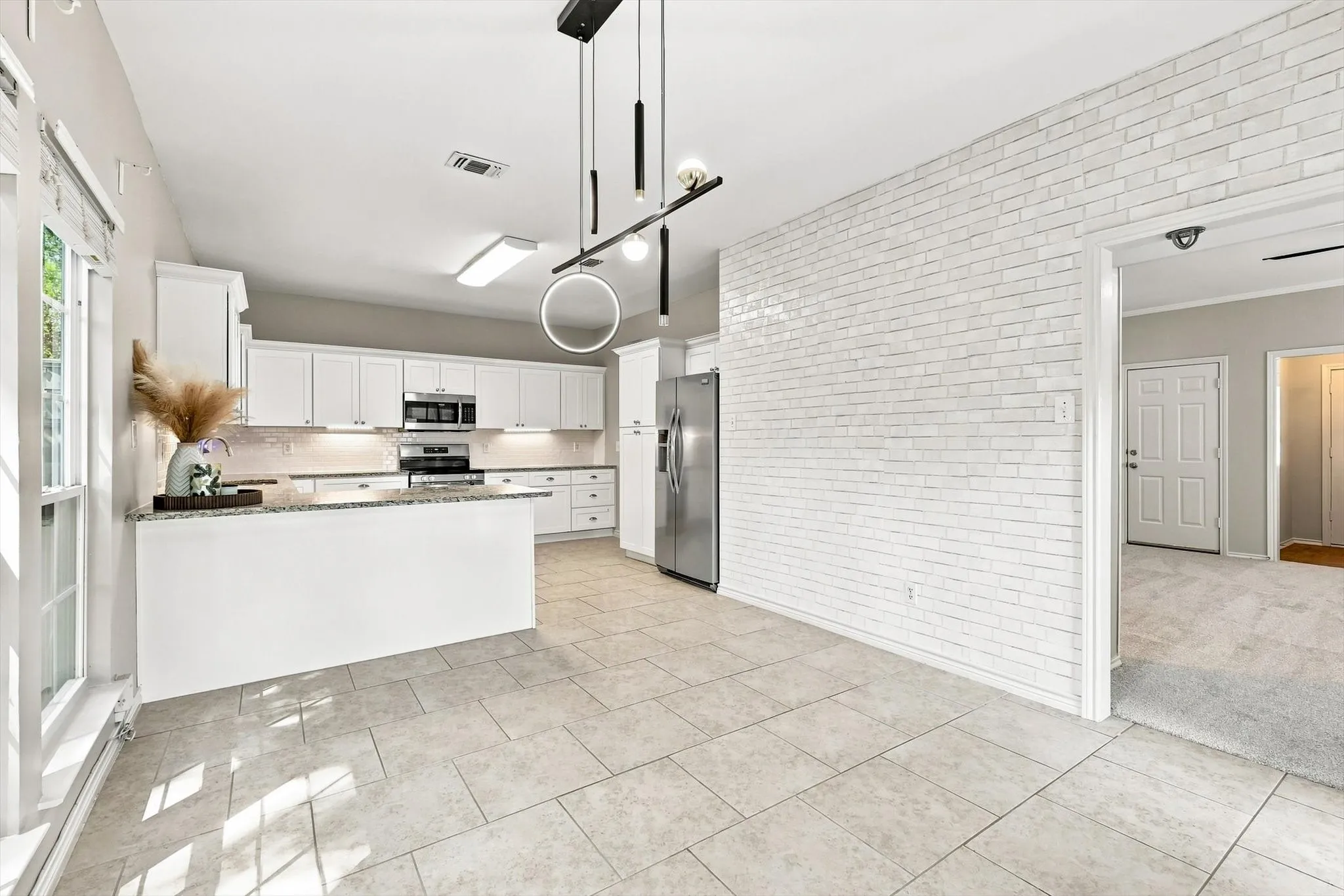 Contemporary kitchen with white cabinetry, stainless steel appliances, a breakfast bar, and tile flooring