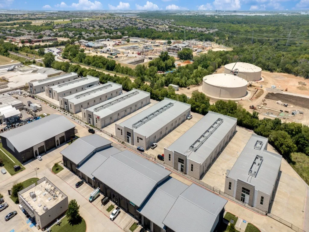 Aerial view highlighting a commercial property featuring multiple industrial-style buildings with metal roofs
