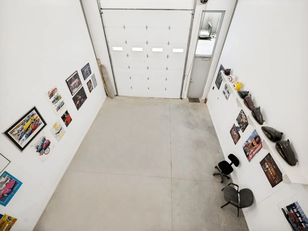 High-bay commercial space featuring a prominent overhead door and concrete flooring